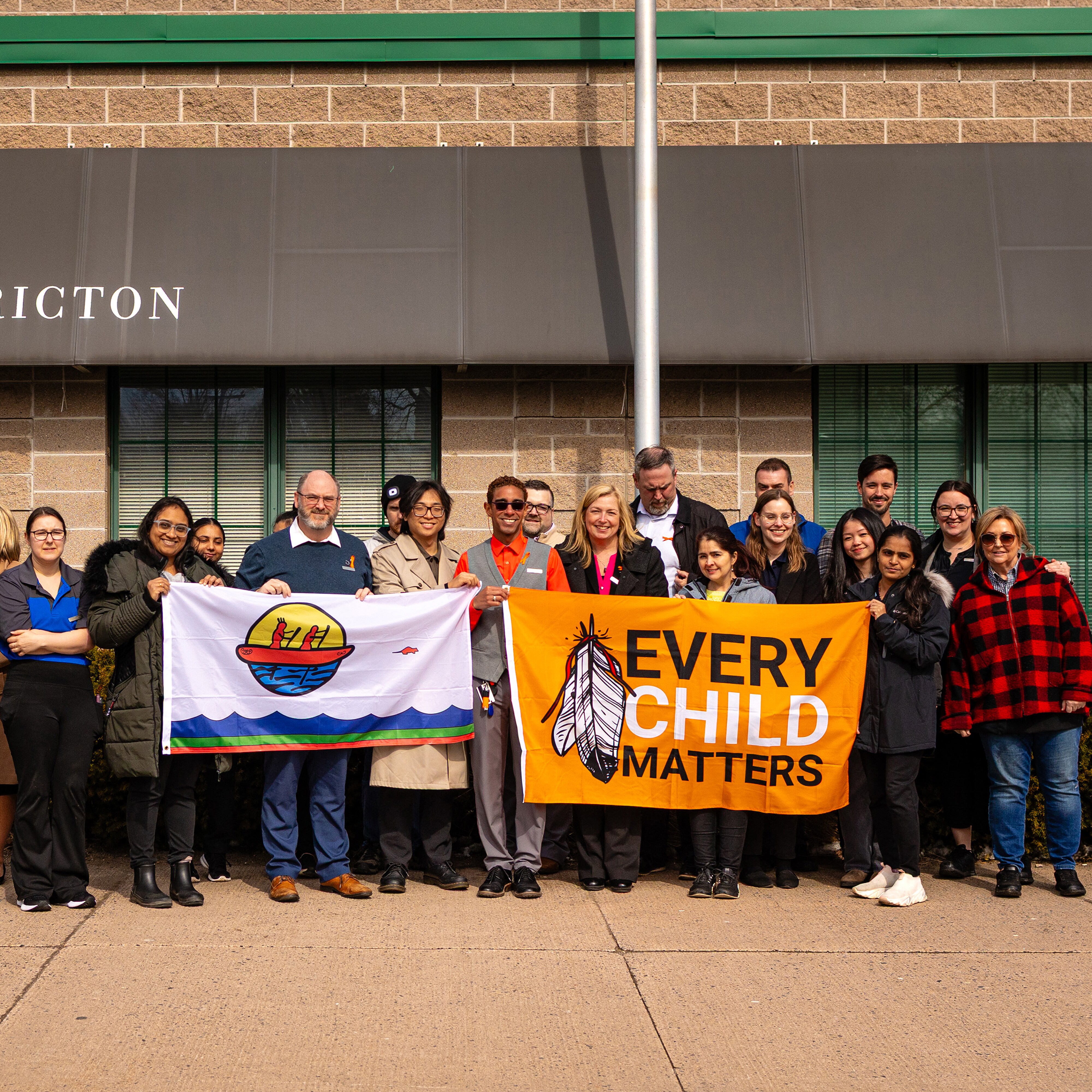 Delta Hotels Fredericton group photo holding signs