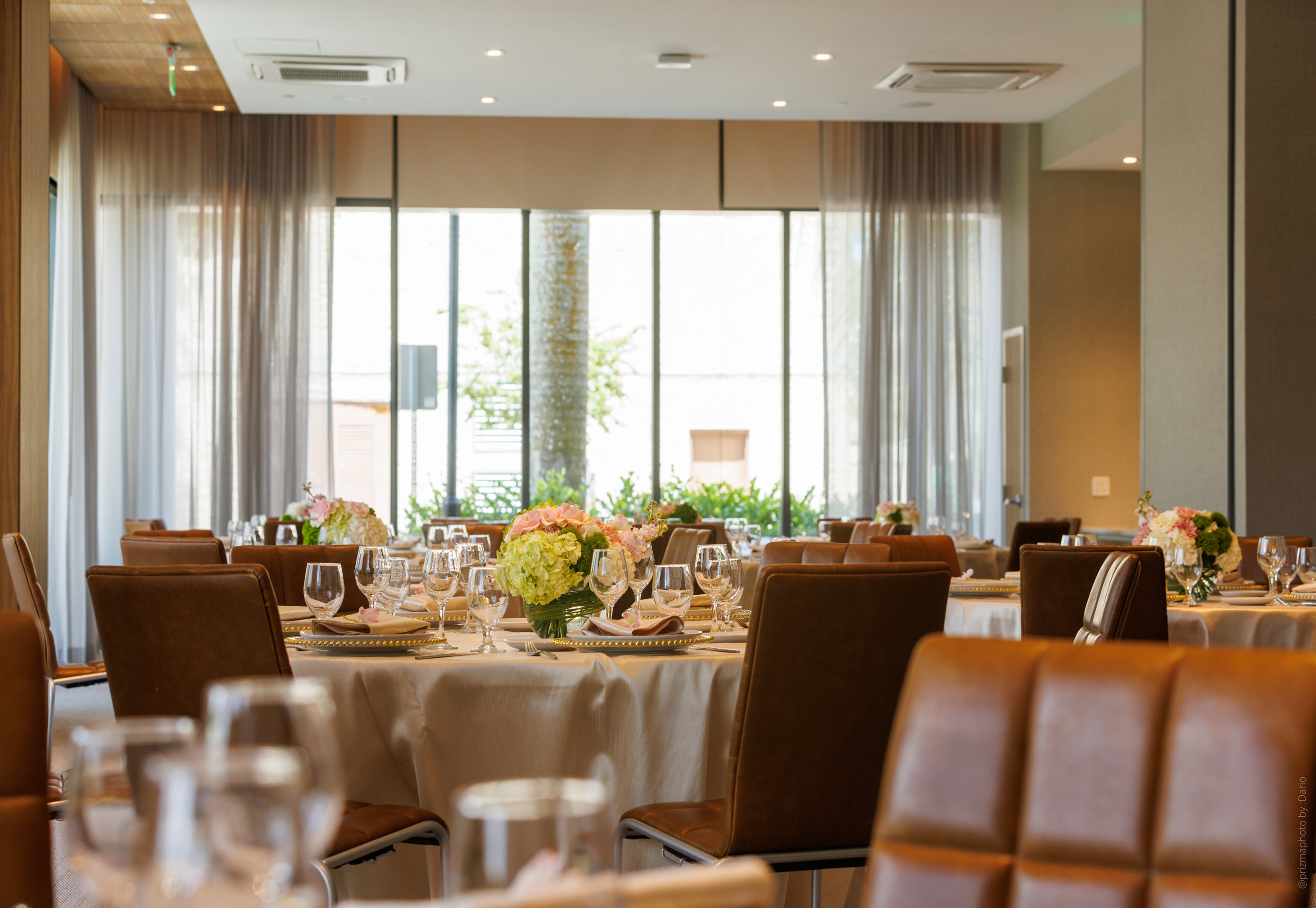 Wedding reception tables in ballroom with large windows