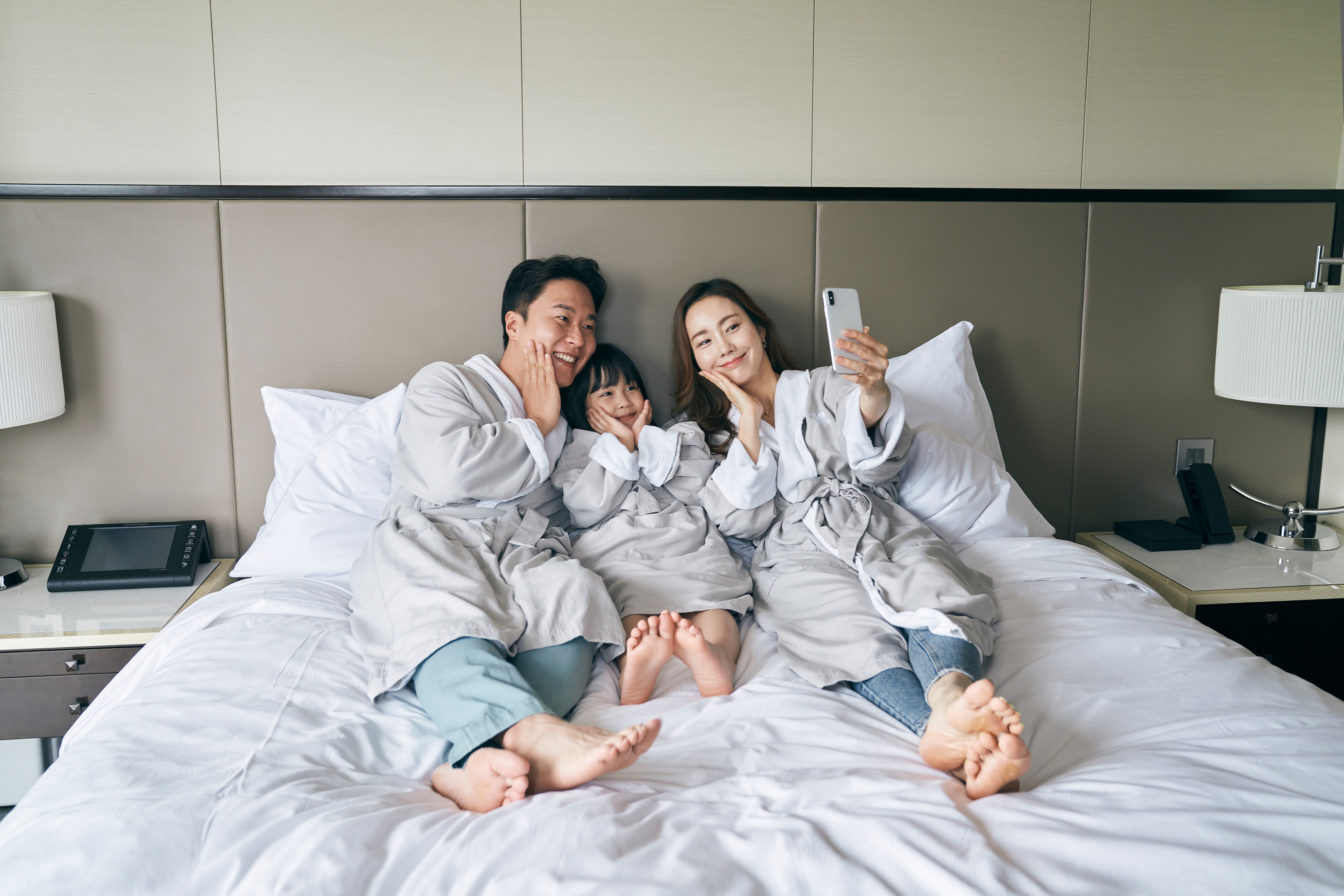객실 침대에서 사진을 찍고 있는 가족