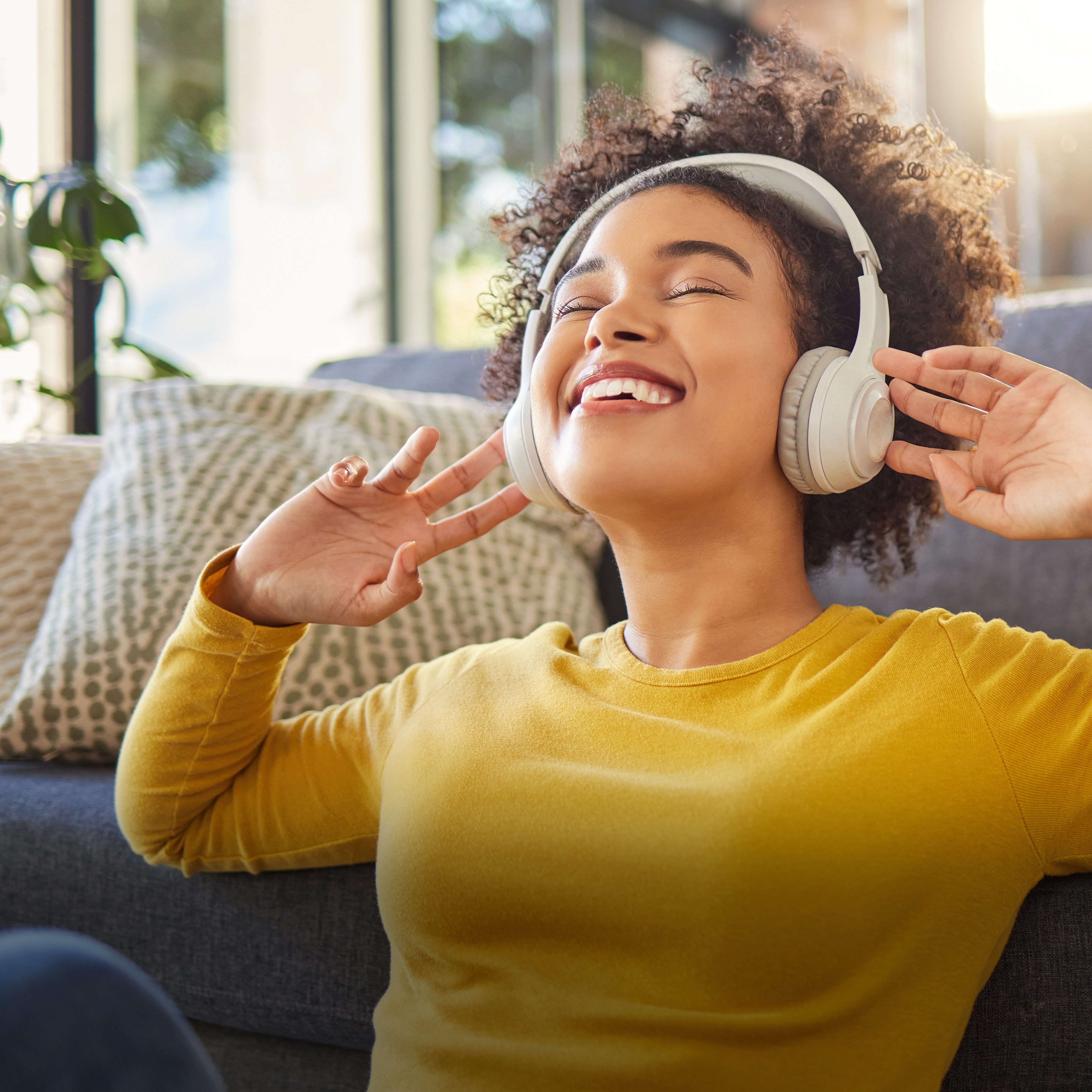 Young woman wearing headphones sitting on floor