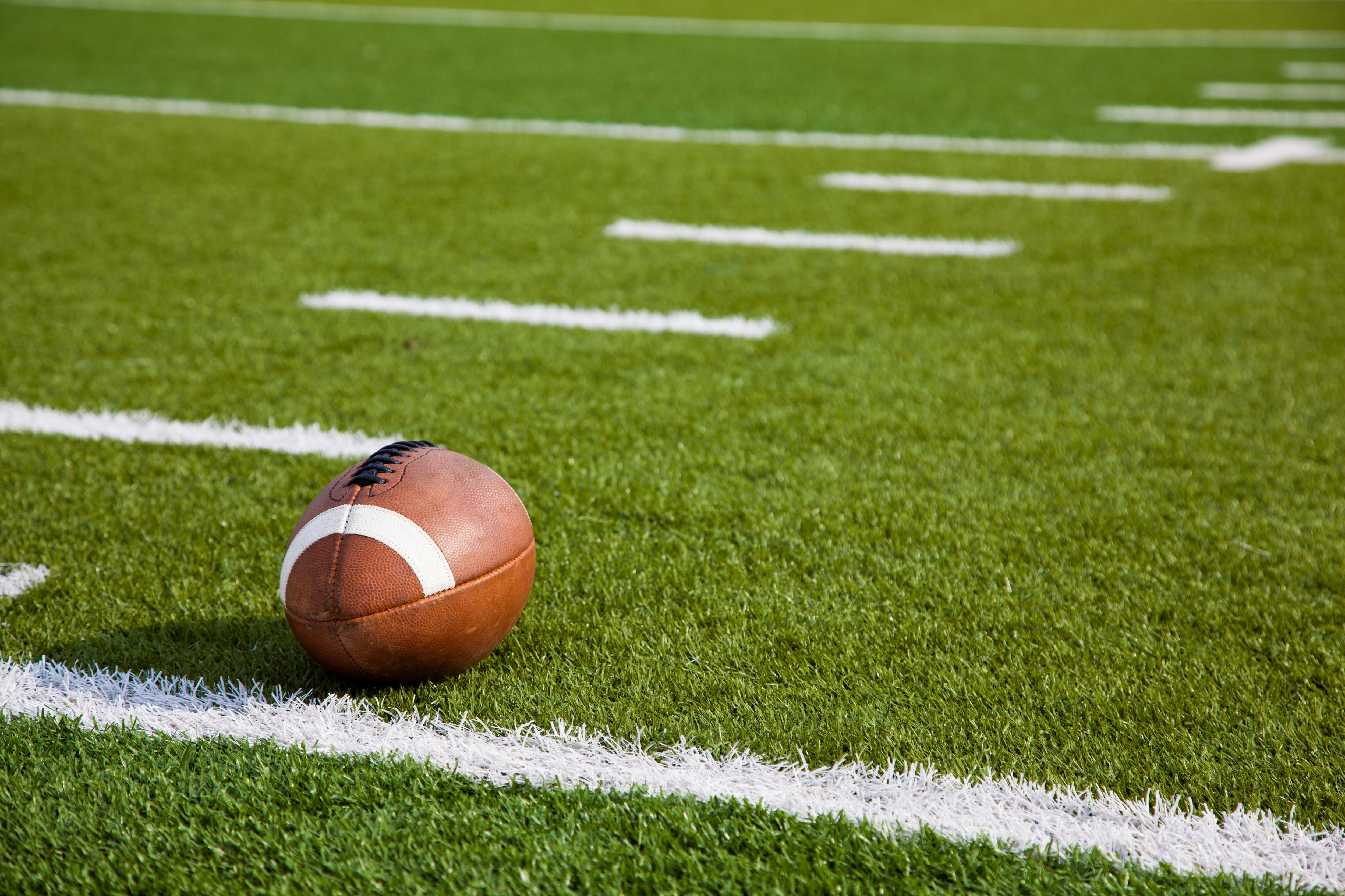 An American football on a green football field