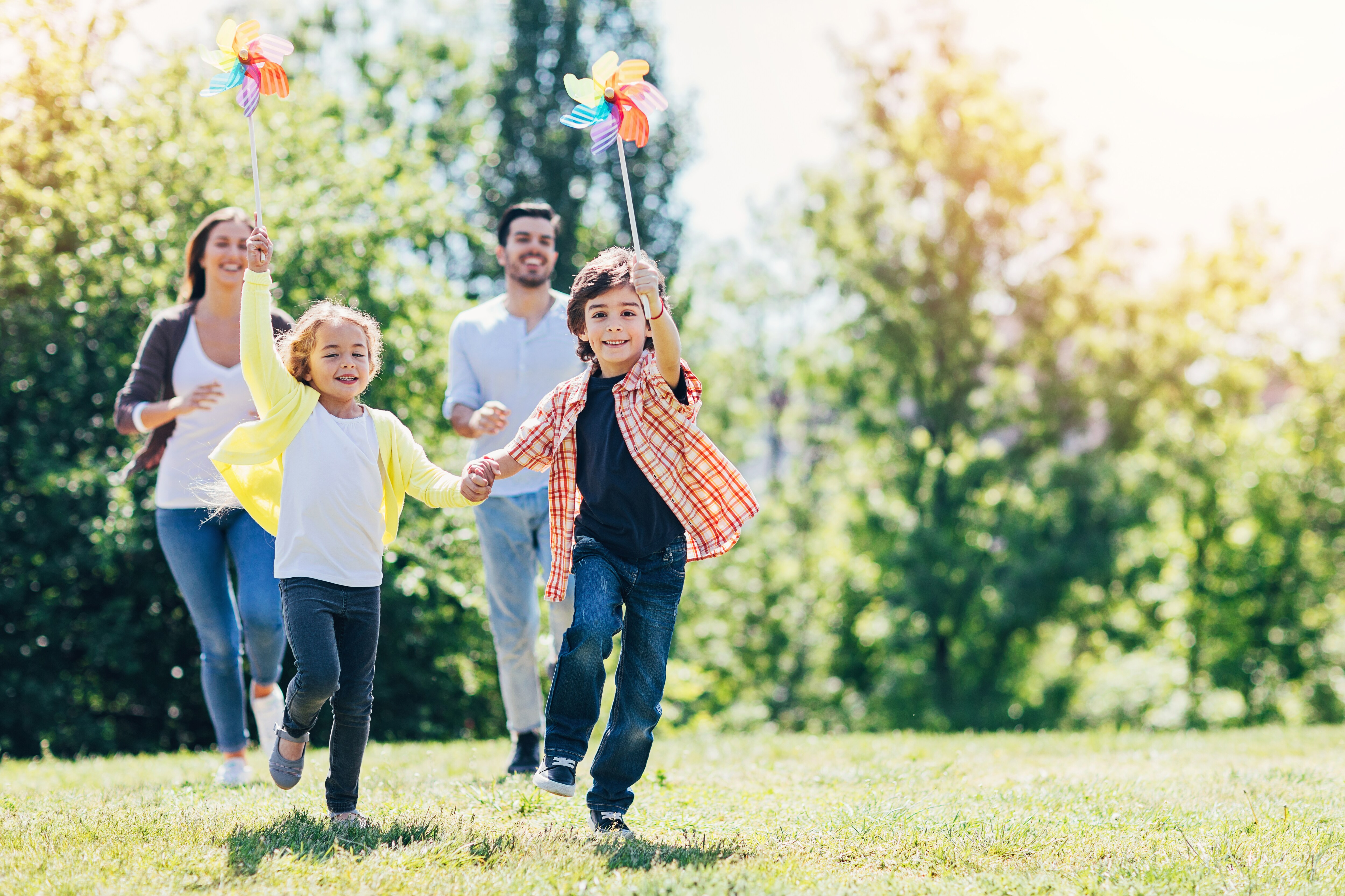 Young family with two children playing on the grass