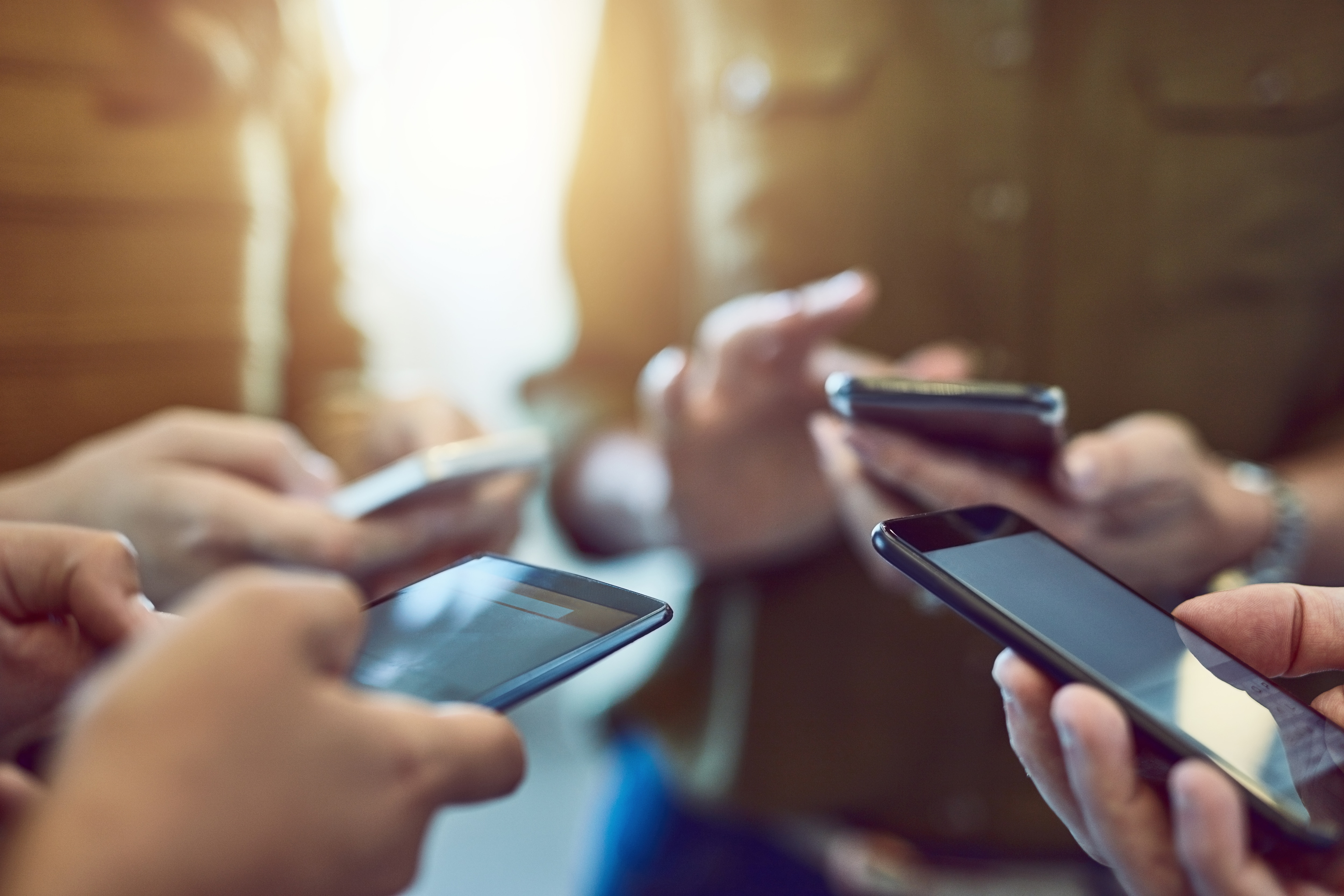 Close-up of a group of people holding smartphones