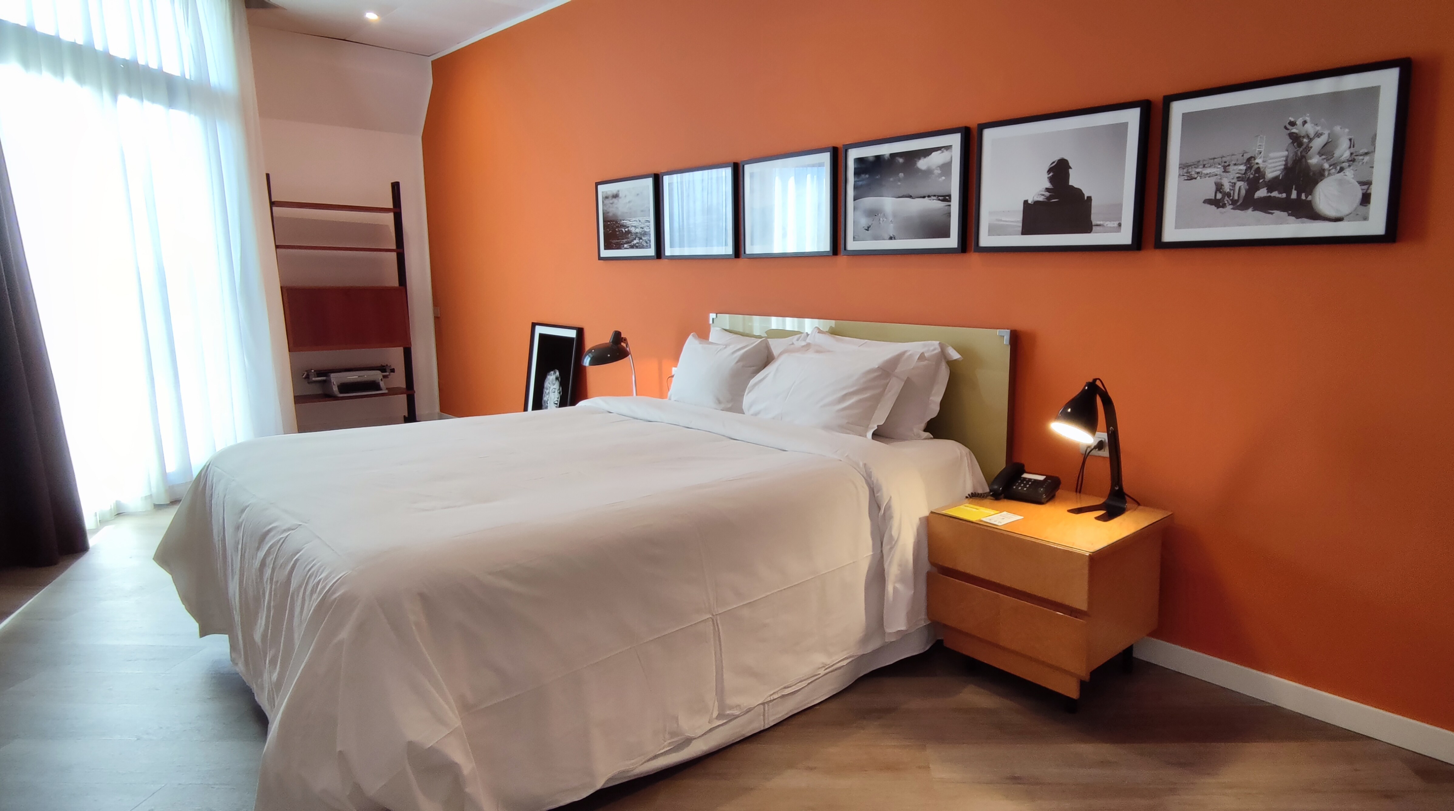 Camera da letto con parete colorata e opere d'arte