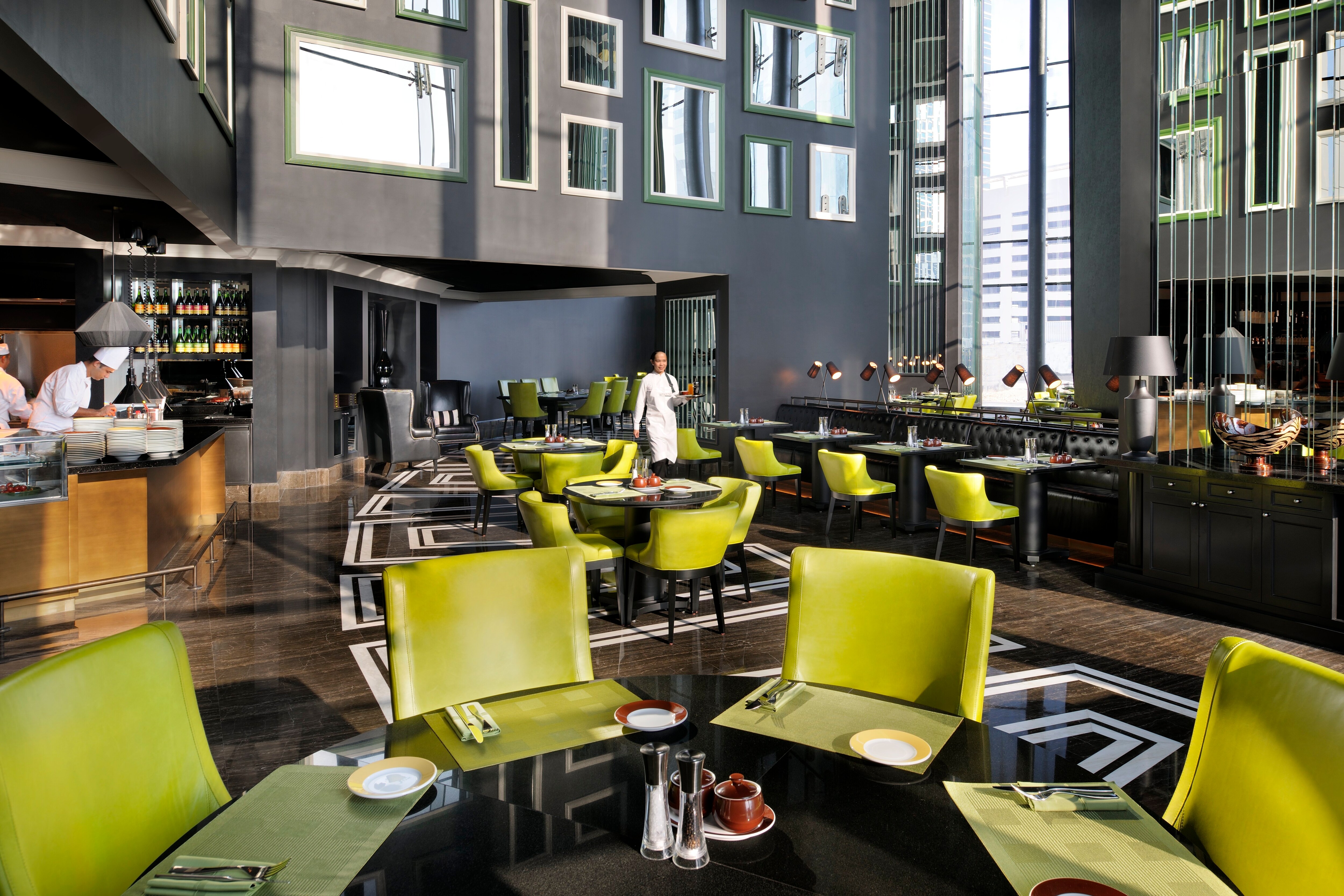 Restaurant dining room with large windows and walls decorated with mirrors in frames
