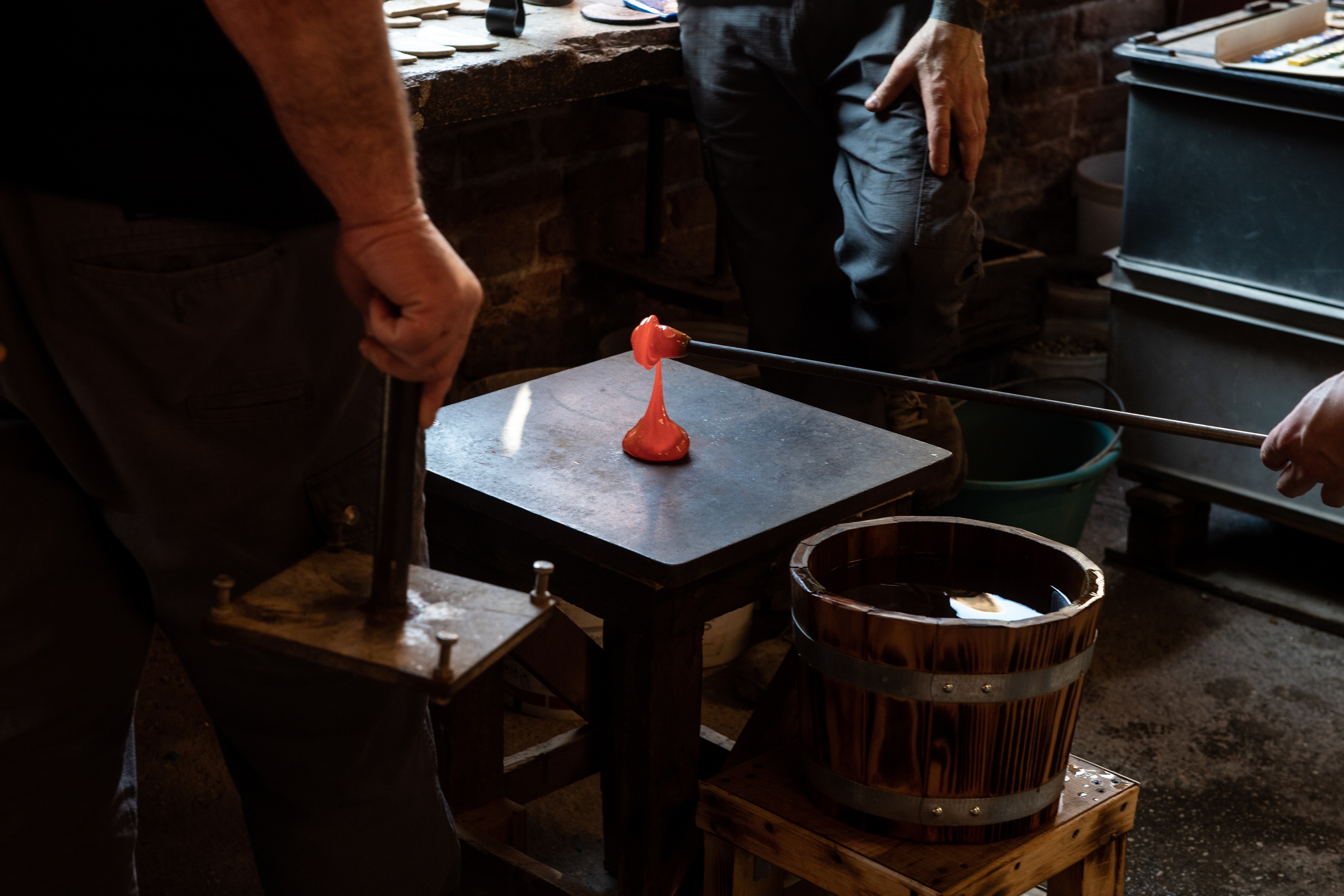 Ouvriers versant du verre en fusion sur un établi