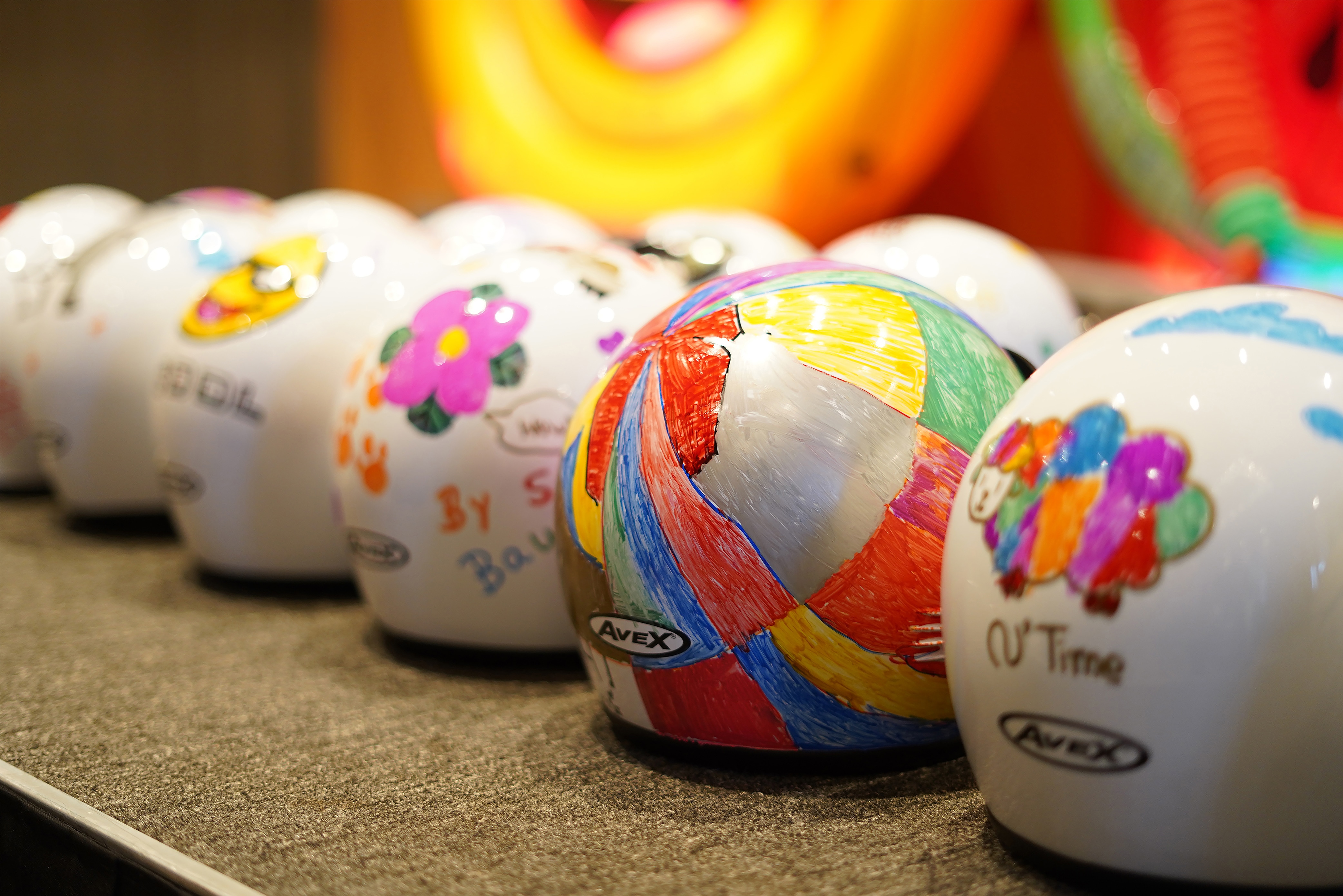 Motorcycle helmets decorated with marker drawings.