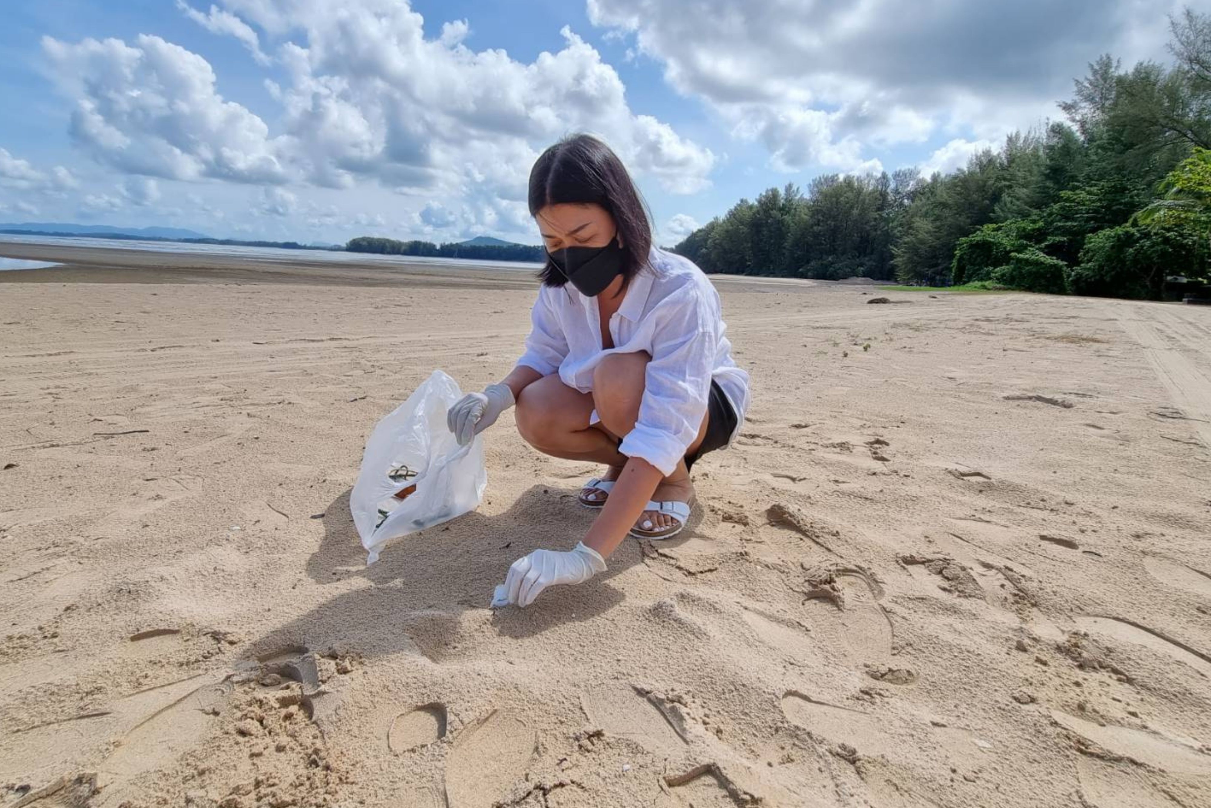 Person picking up litter on the beach