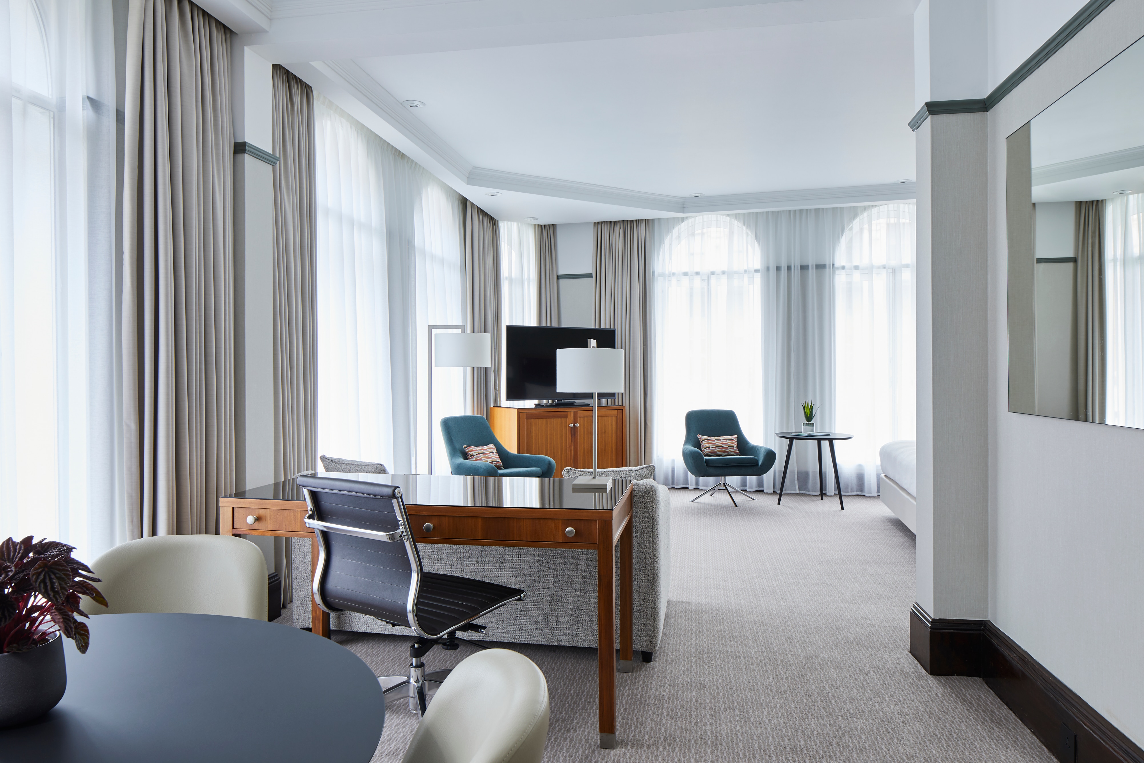 Corner suite with arched floor-to-ceiling windows along both walls