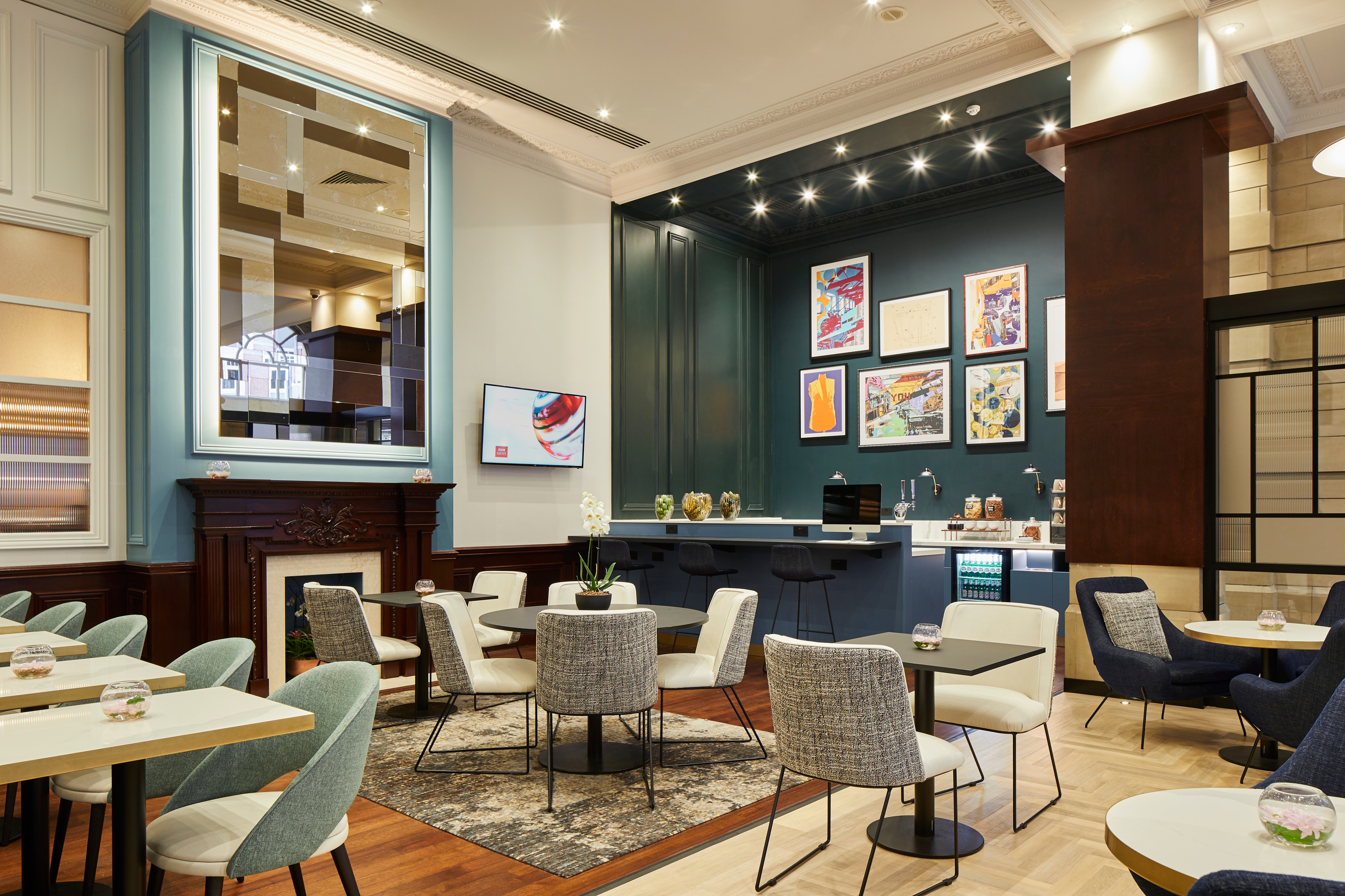 Executive Lounge with tables, upholstered seating, recessed lighting and art on walls