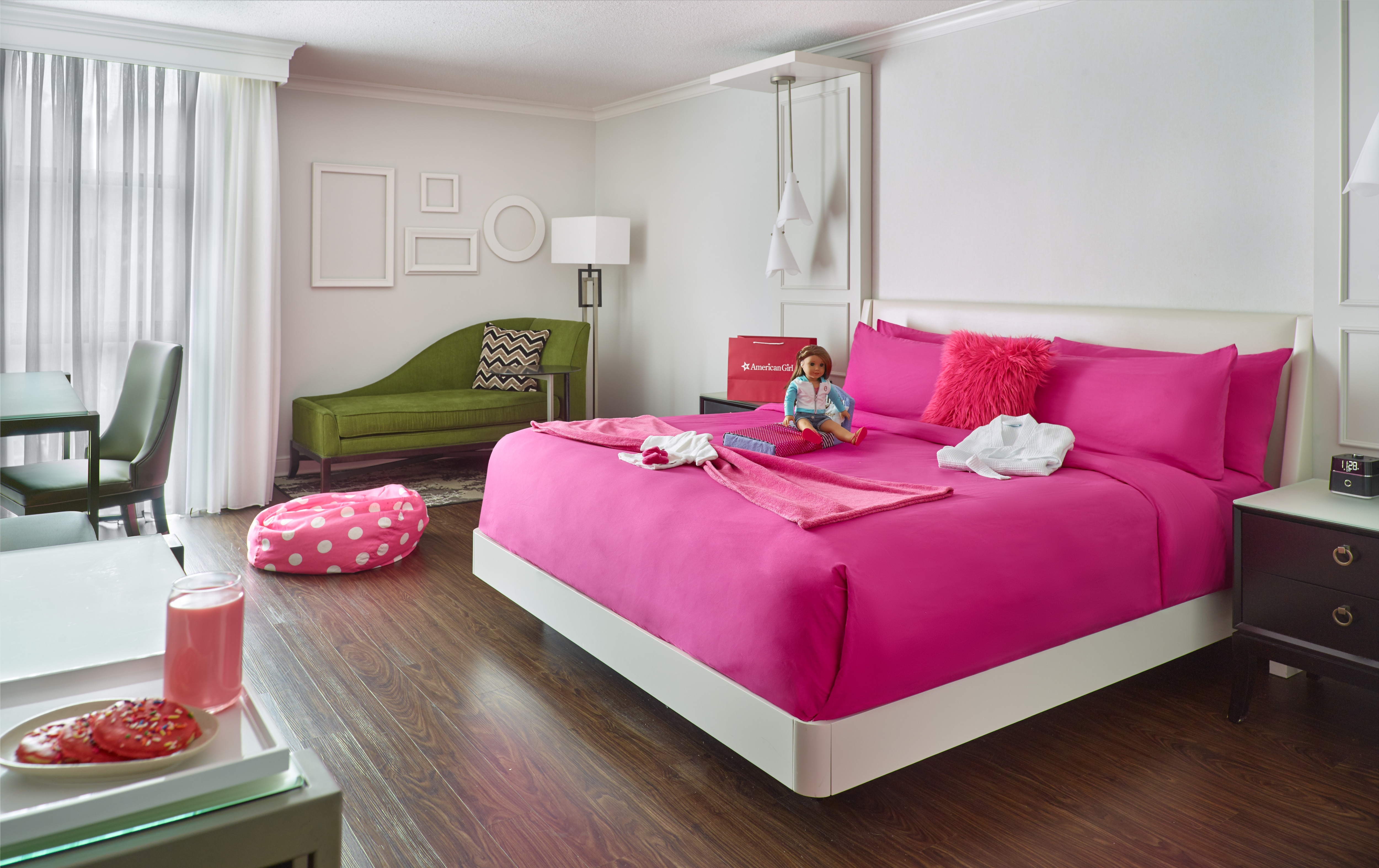 American Girl PINK American Girl PINK Room with white walls, green furniture, and bright pink bedding, as well as American Girl merchandise.