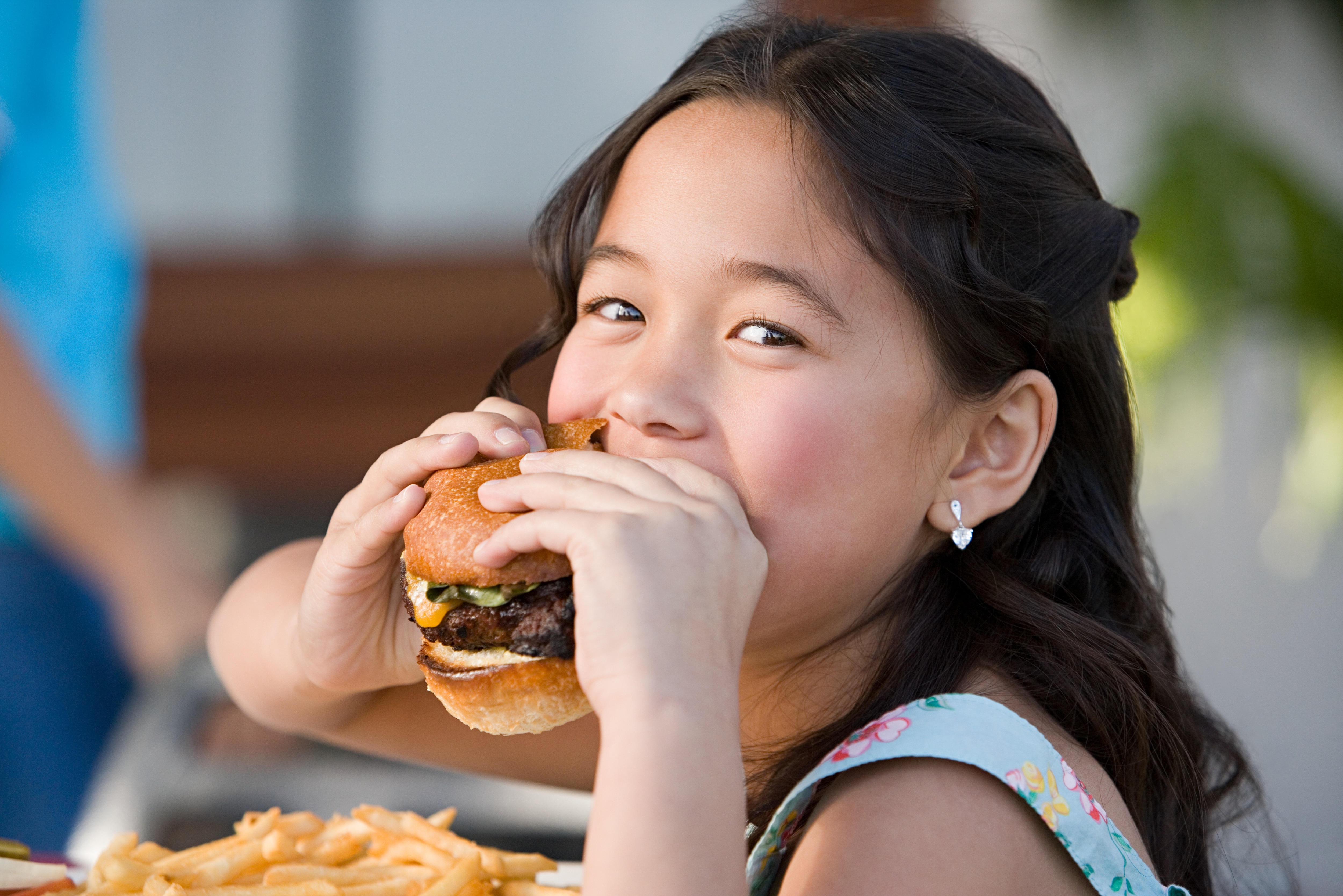 Girl eating a burger and smiling