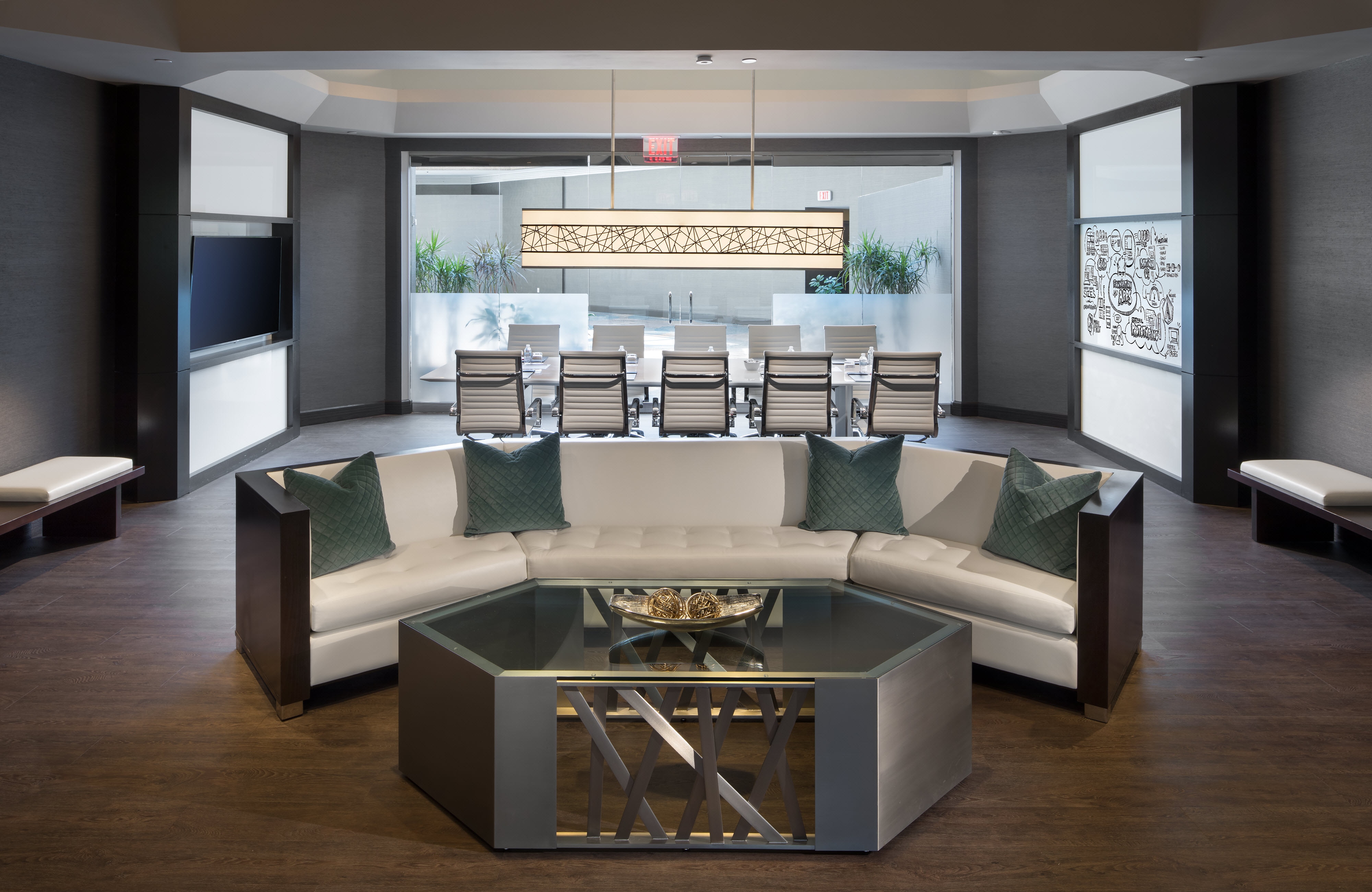 Boardroom with white sofa, board table, chairs, and chandelier