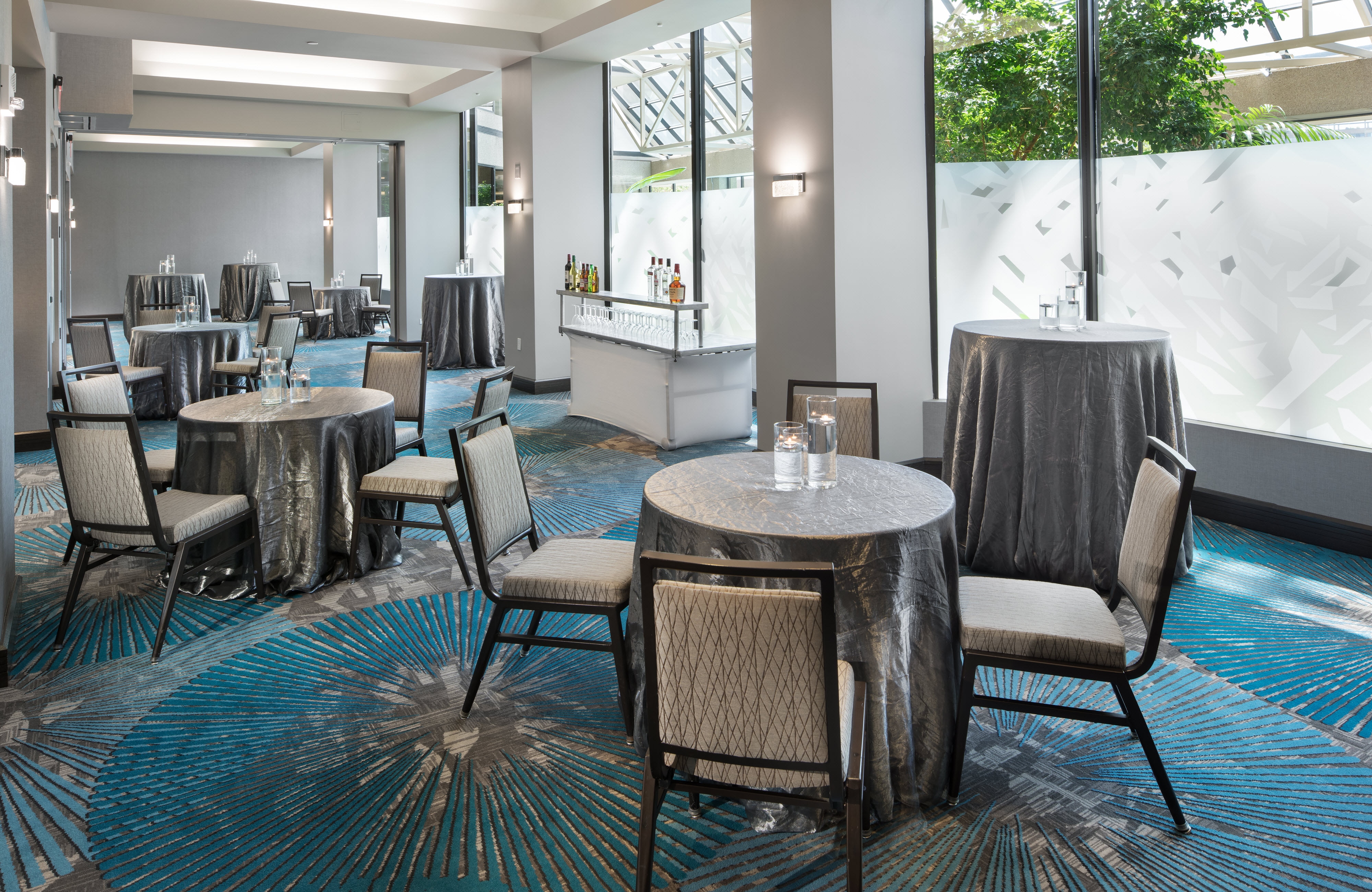 Round tables set with floating tealights in room with partially frosted windows