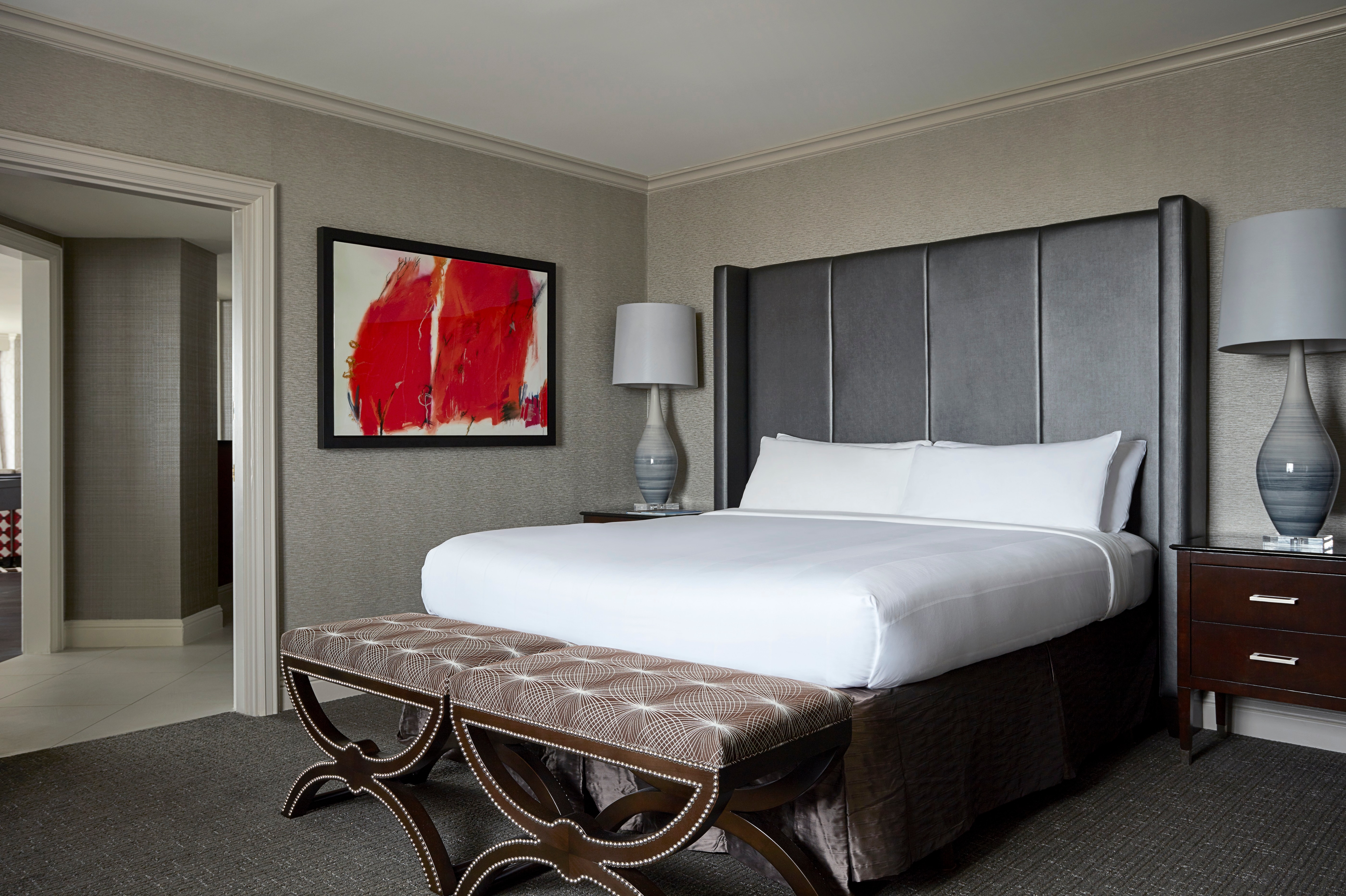 Bed with large headboard and nightstands with lamps