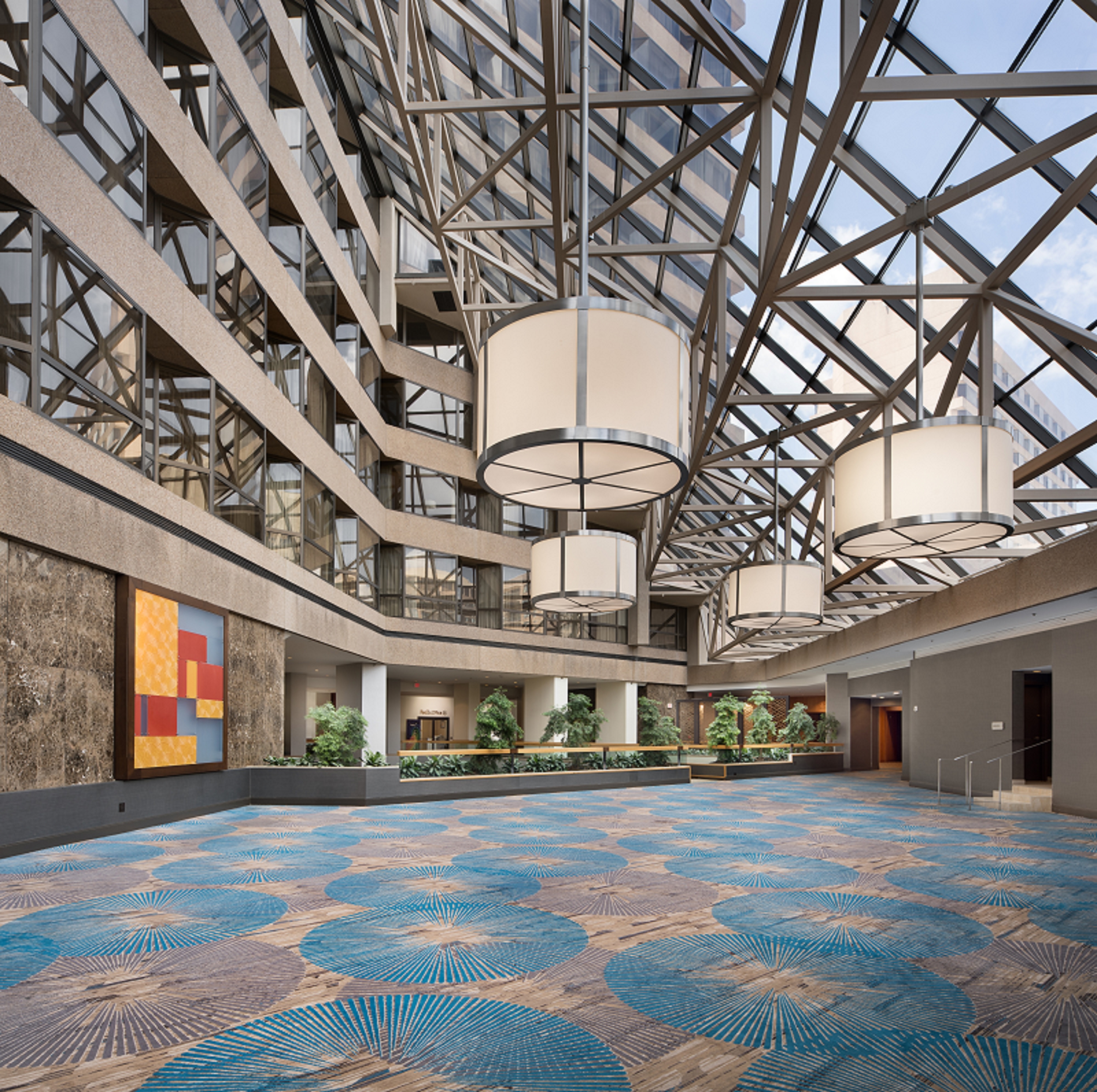 Carpeted terrace with glass roof, chandeliers and indoor plants