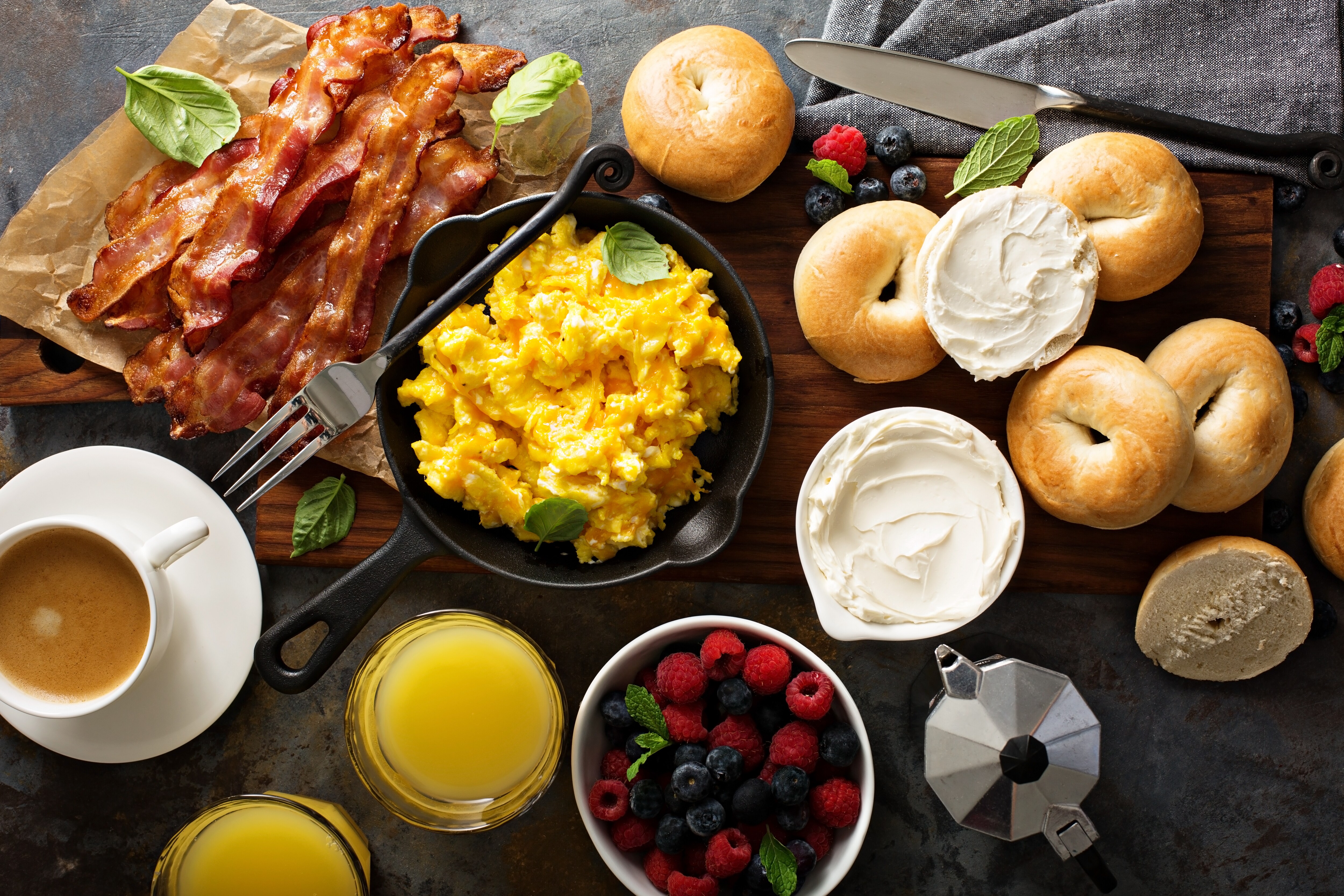 Breakfast spread with bagels, bacon, fresh berries and juice