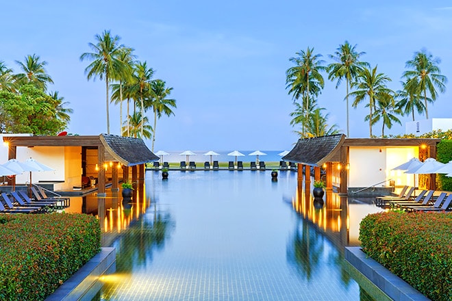 Cabanas next to pool with ocean in background