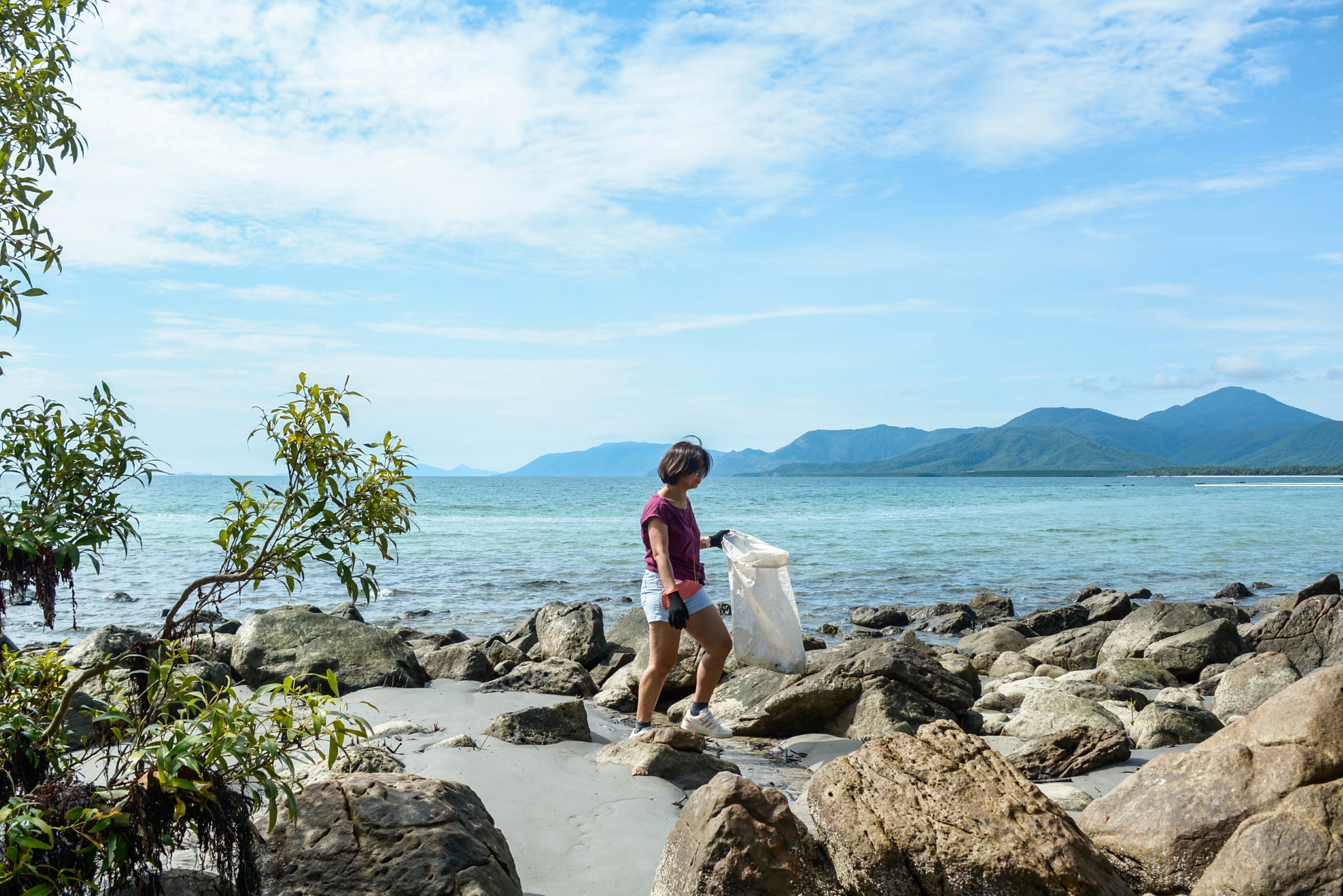 Person looking for litter on the beach.