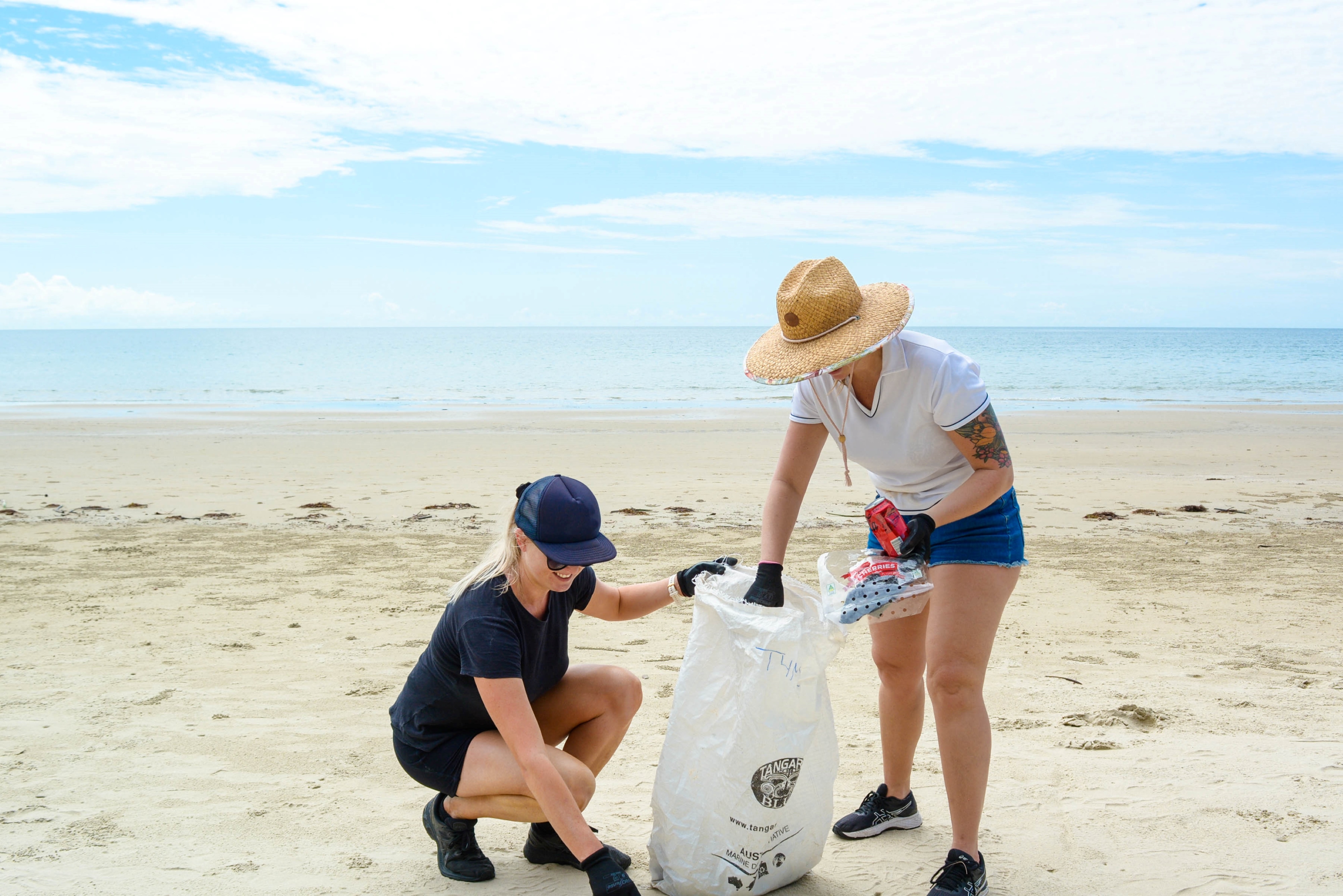 People picking up litter on the beach.