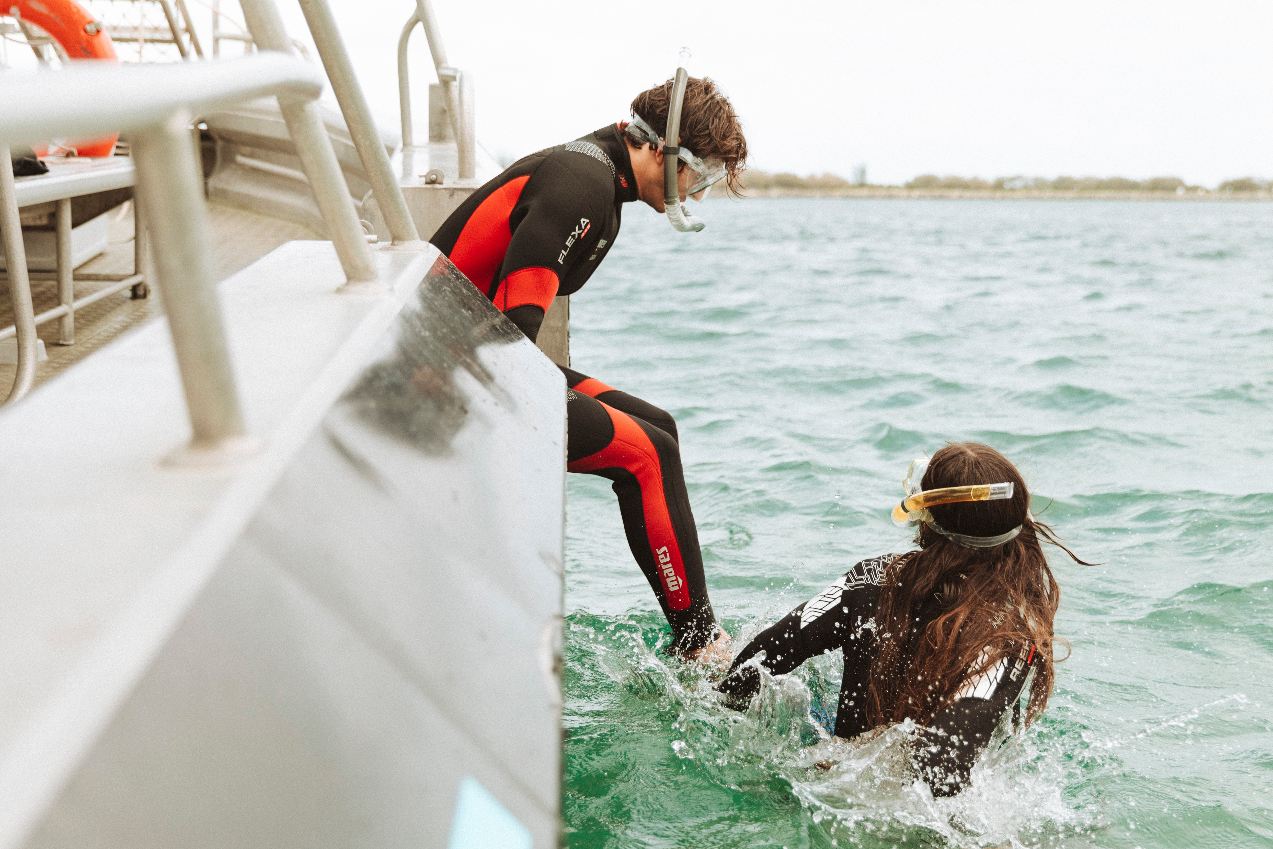 Couple diving off a boat into the Seaway