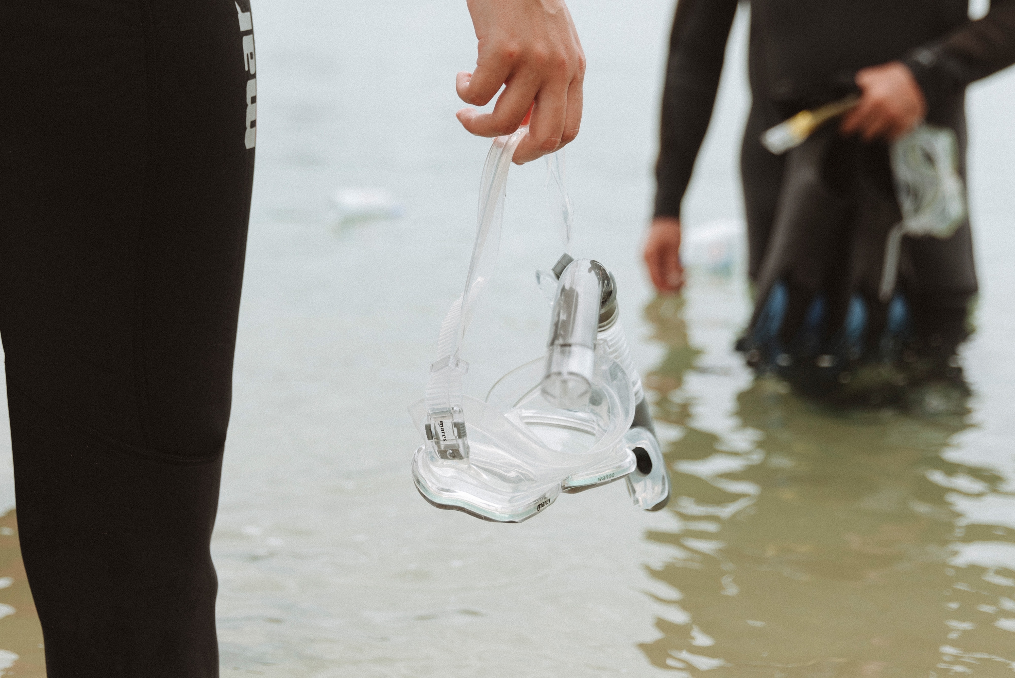Close up of hand holding snorkel over water 