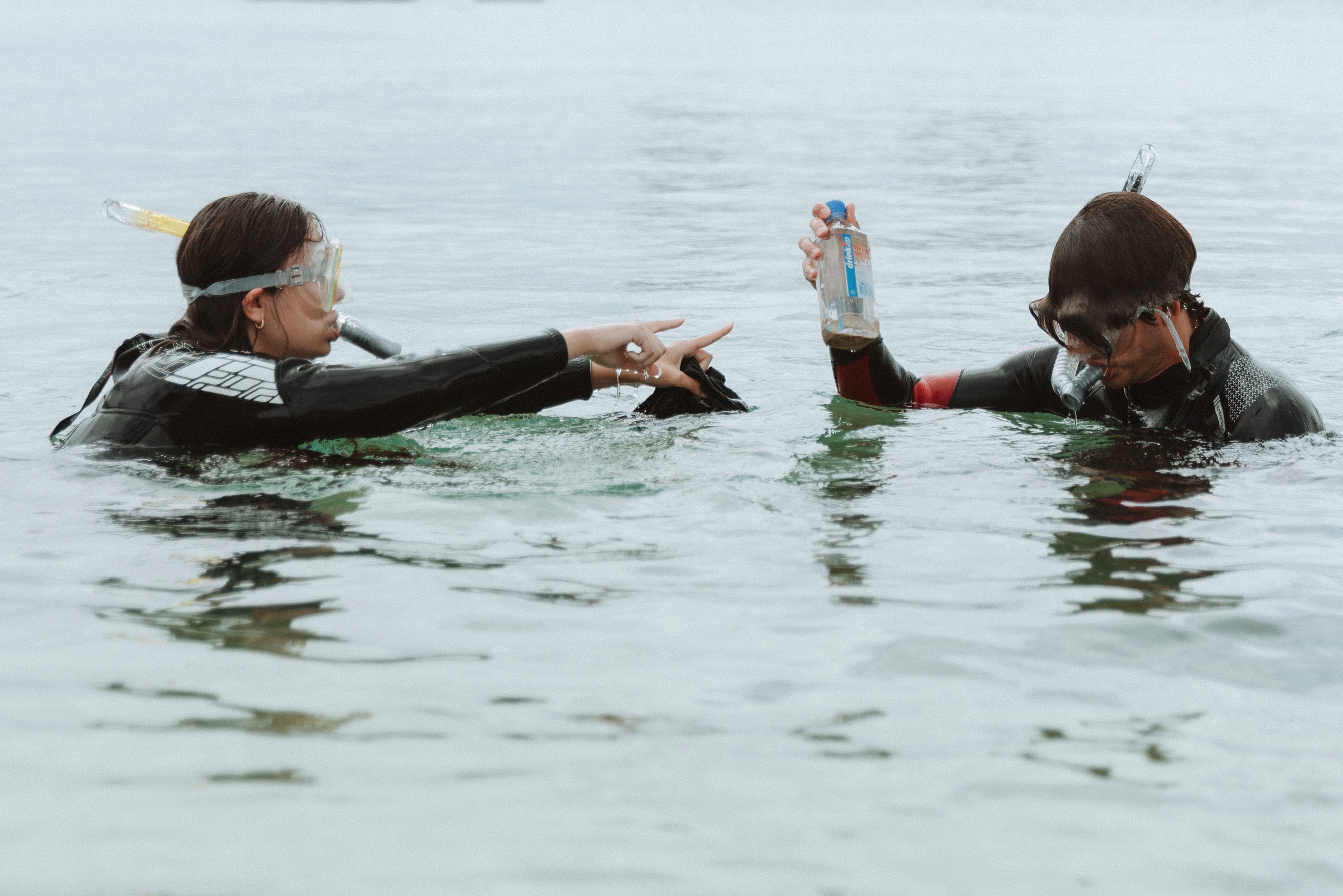 Couple snorkeling and collecting debris