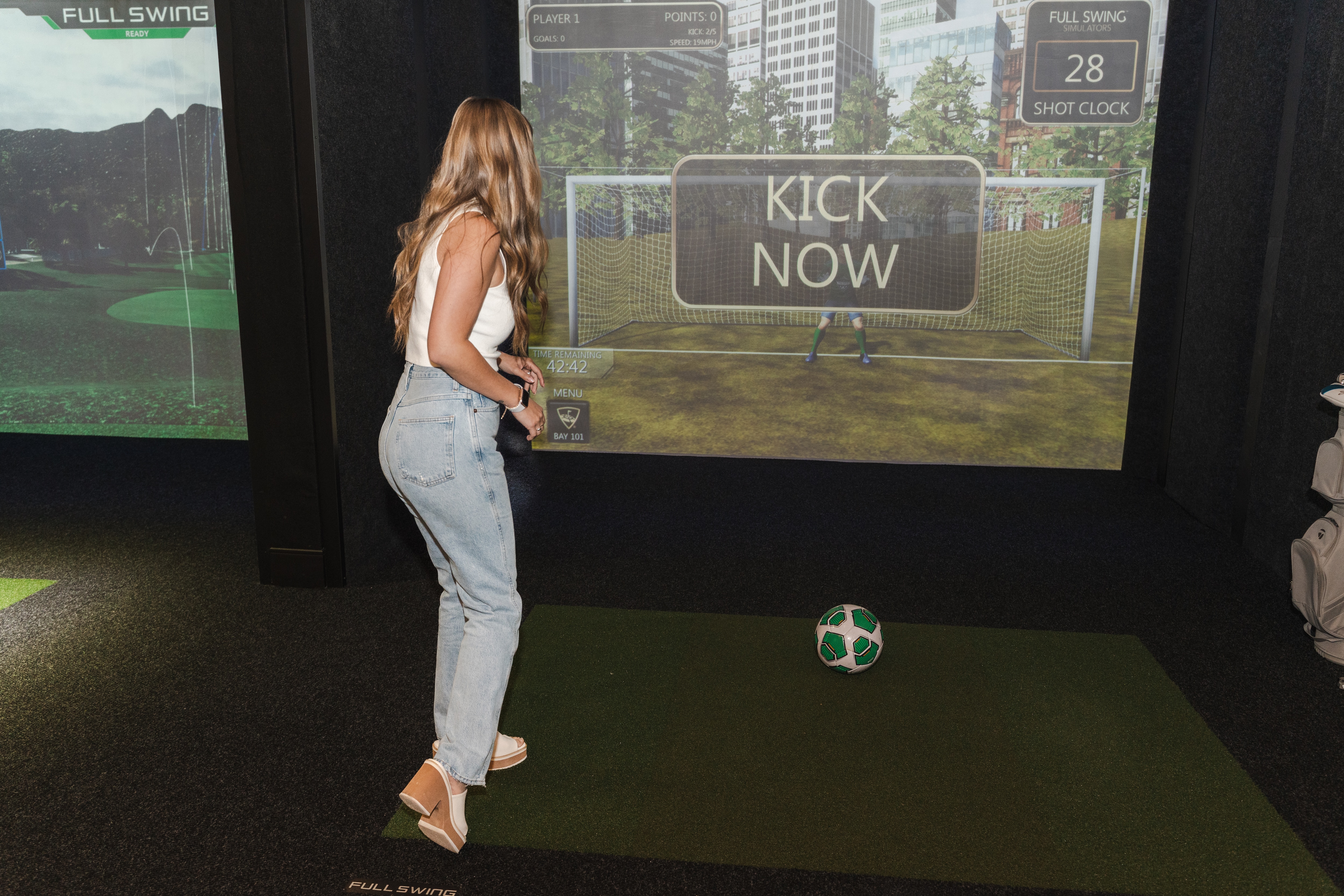 Person playing soccer in the Topgolf swing suite