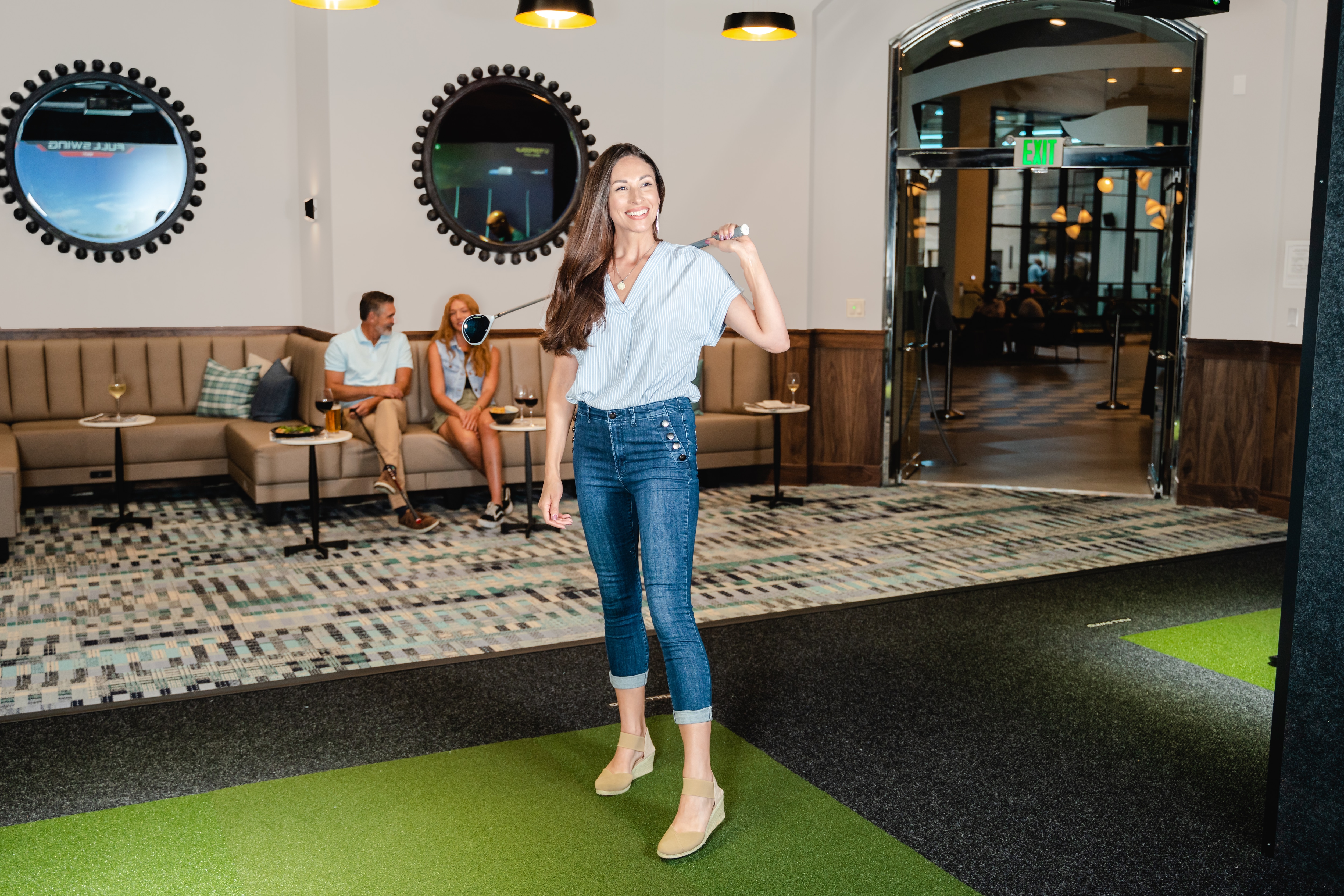 Person golfing in the Topgolf swing suite