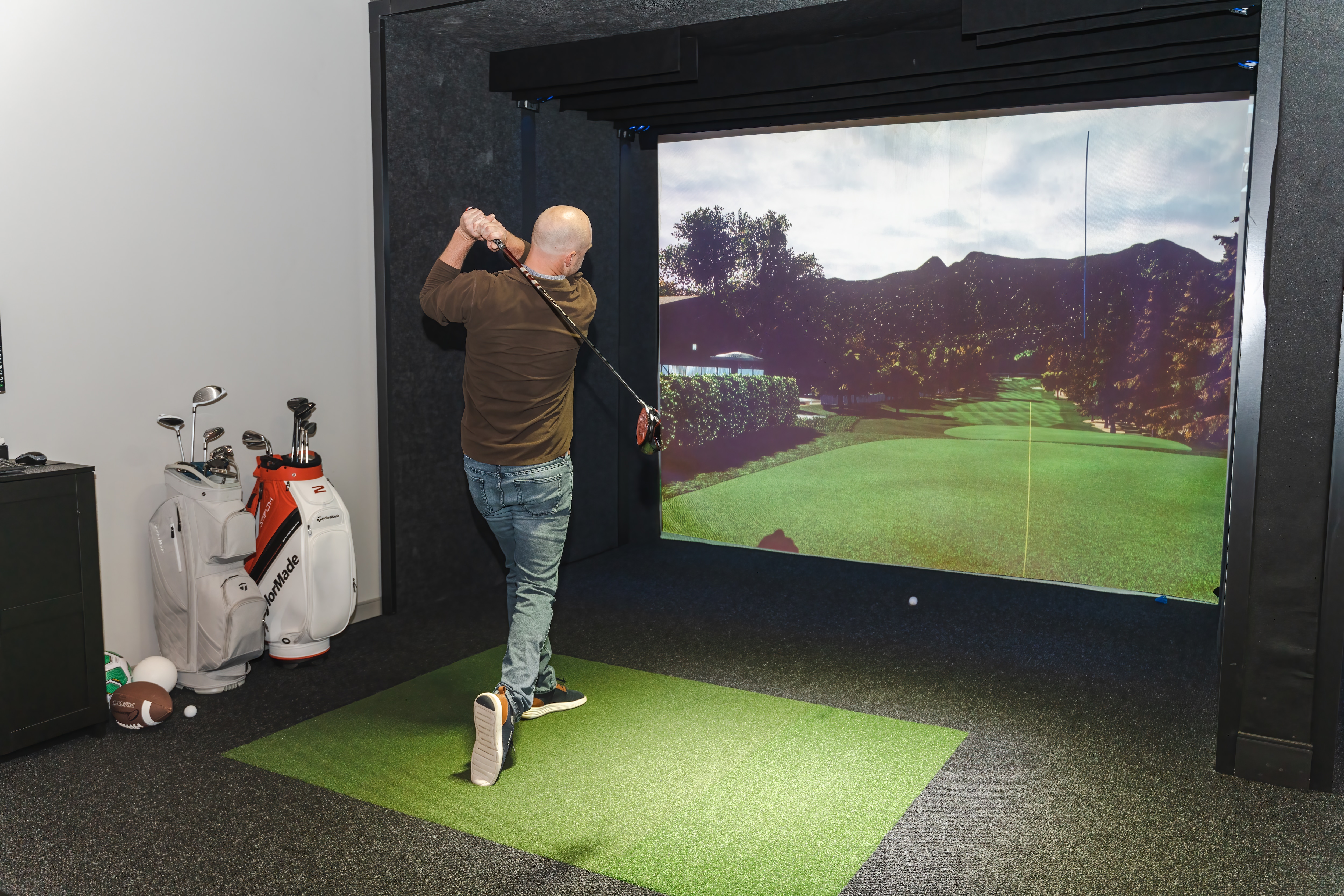 Person golfing in the Topgolf swing suite