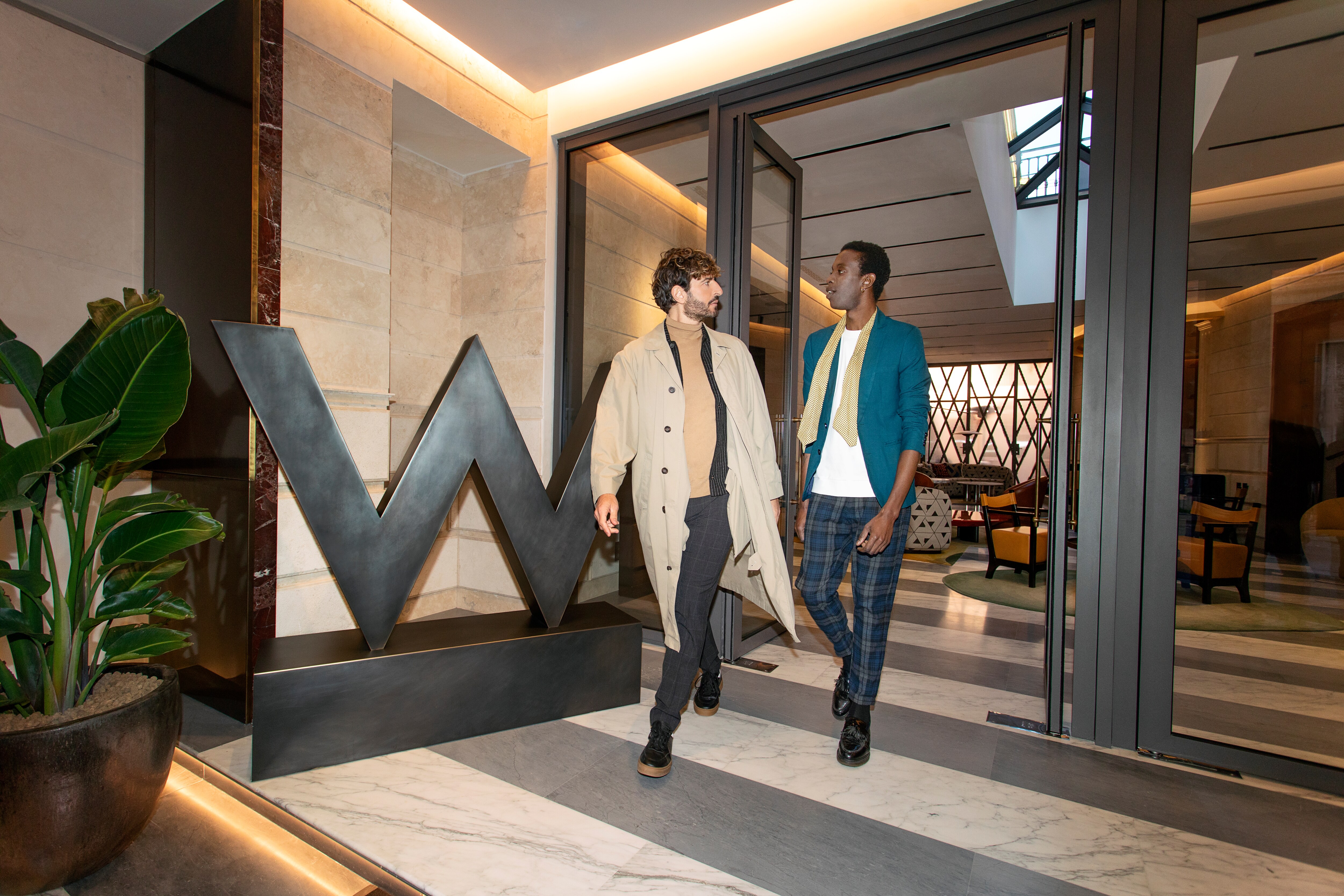 Two people walking in the hotel entryway