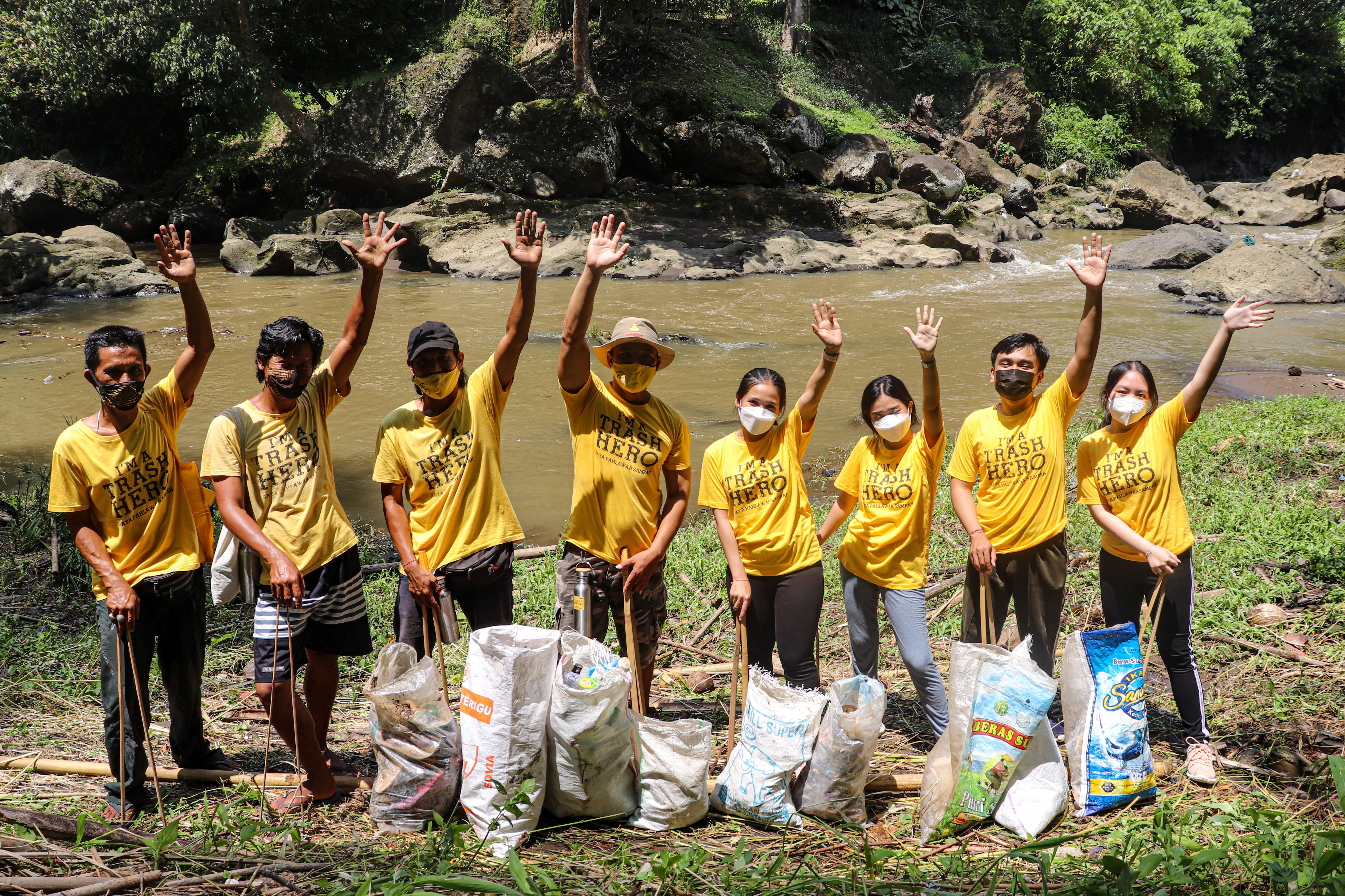 Trash Hero volunteers waving from riverbank
