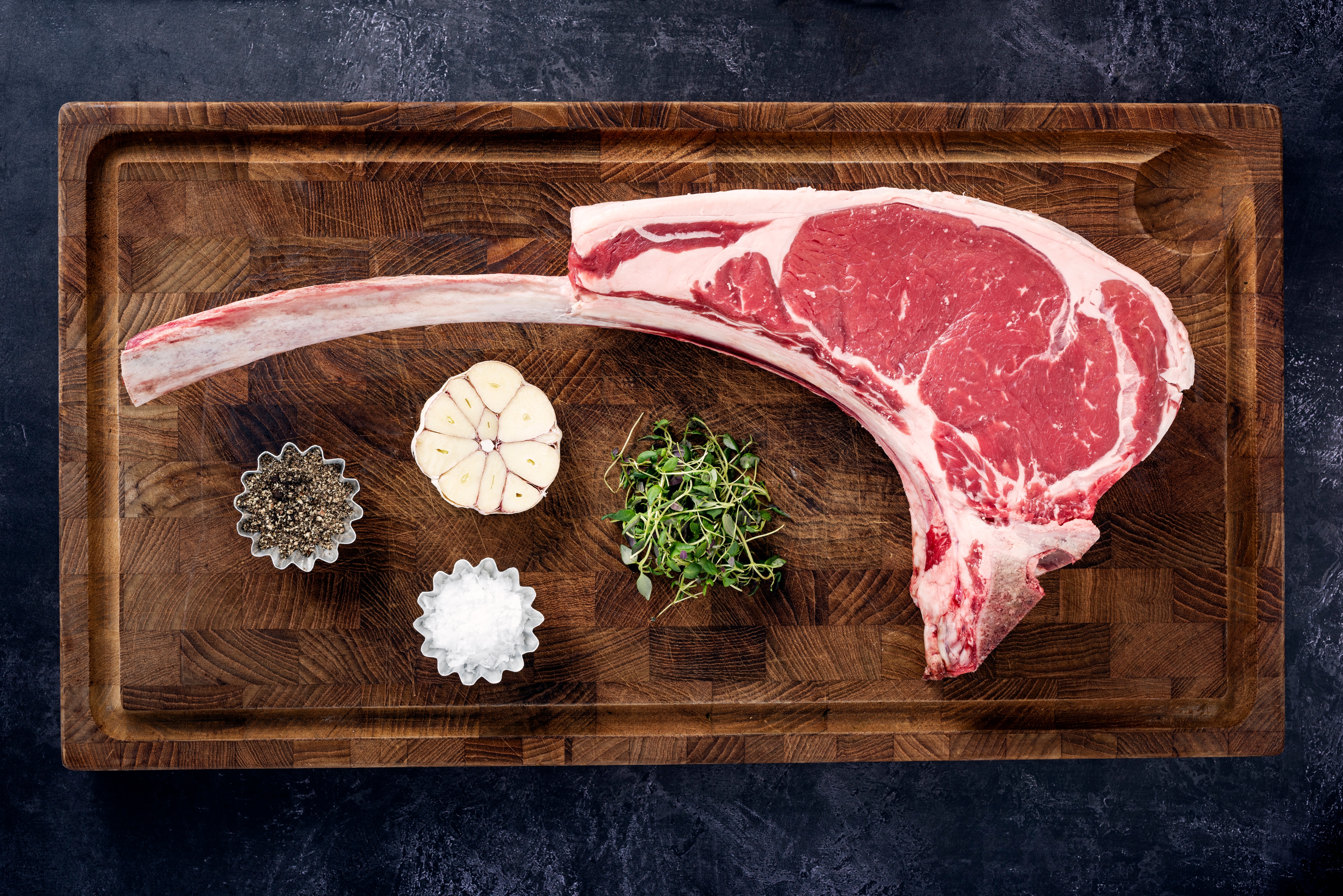 A cut of steak on a cutting board with spices