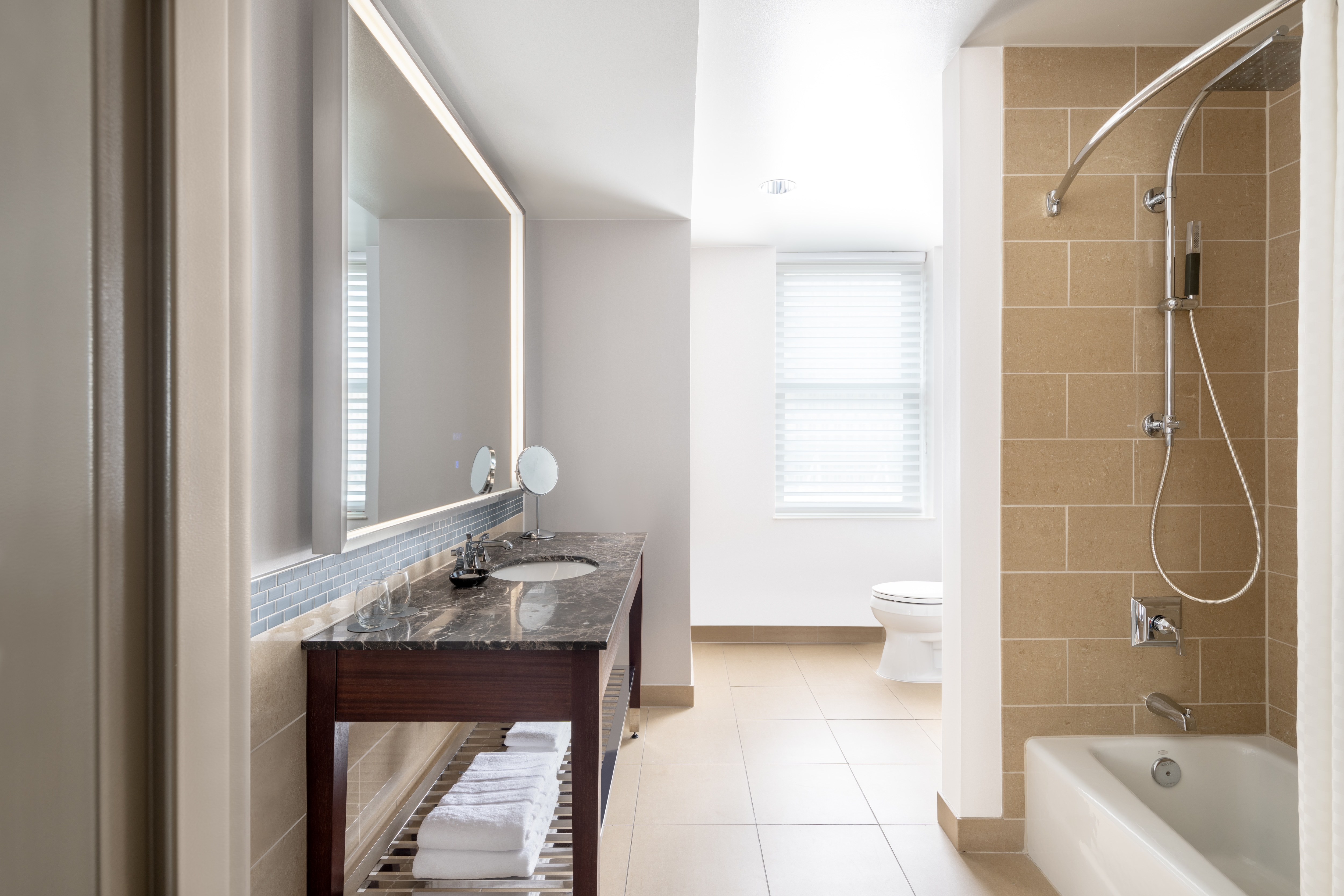 Guest bathroom with bathtub and showerhead and large vanity