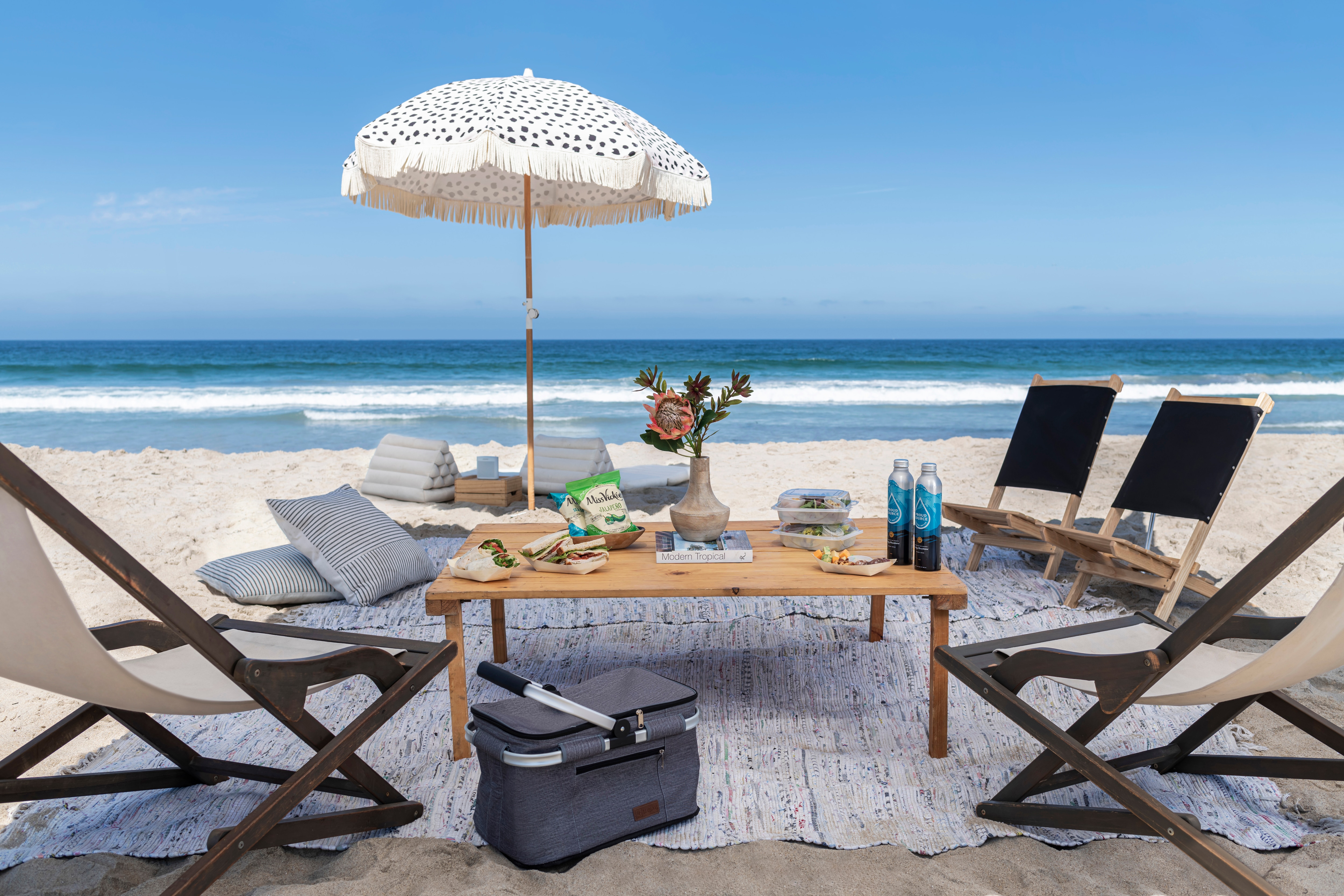 Chairs, umbrella and table with food on the beach.