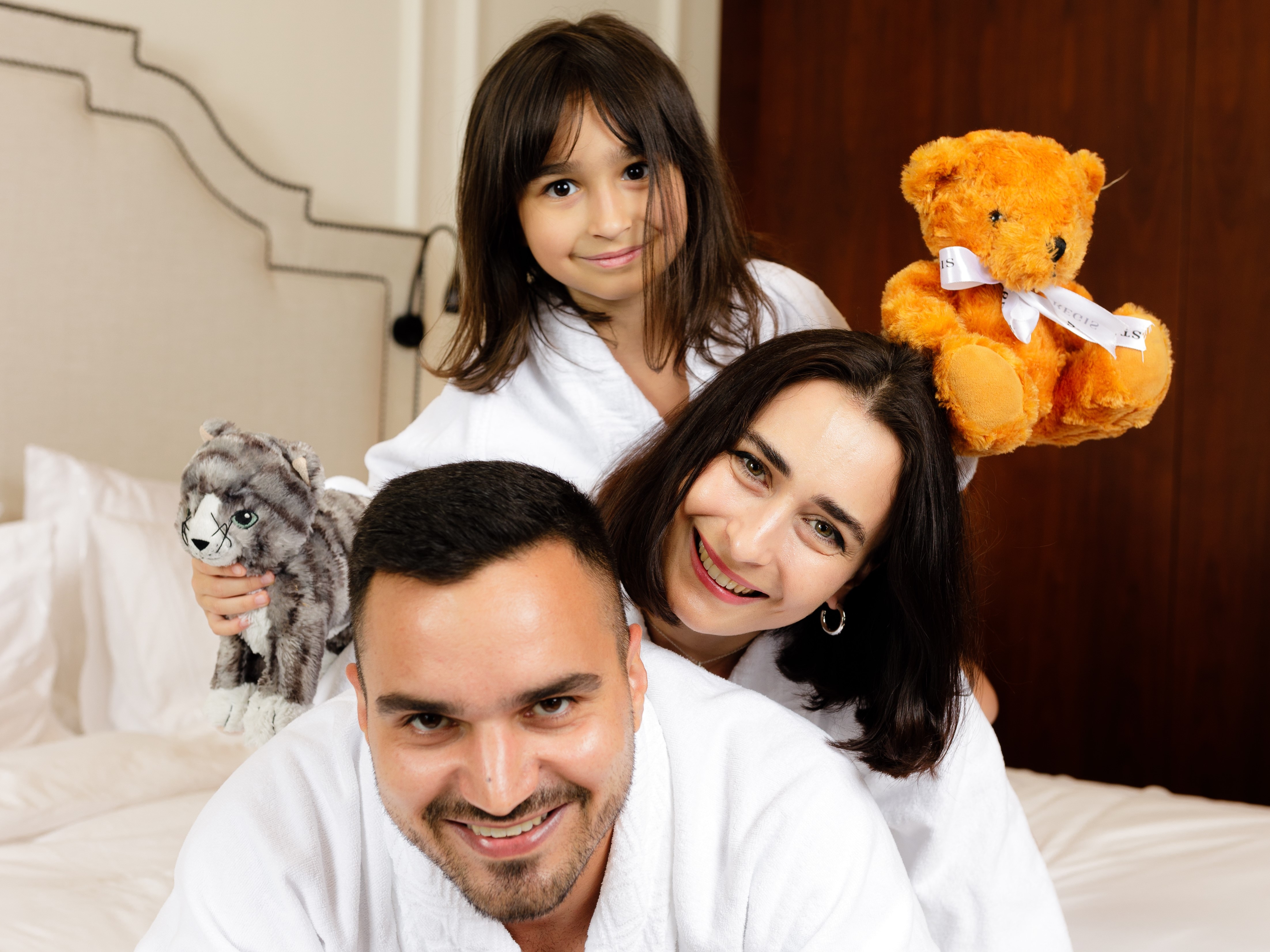 Family posing with stuffed animals