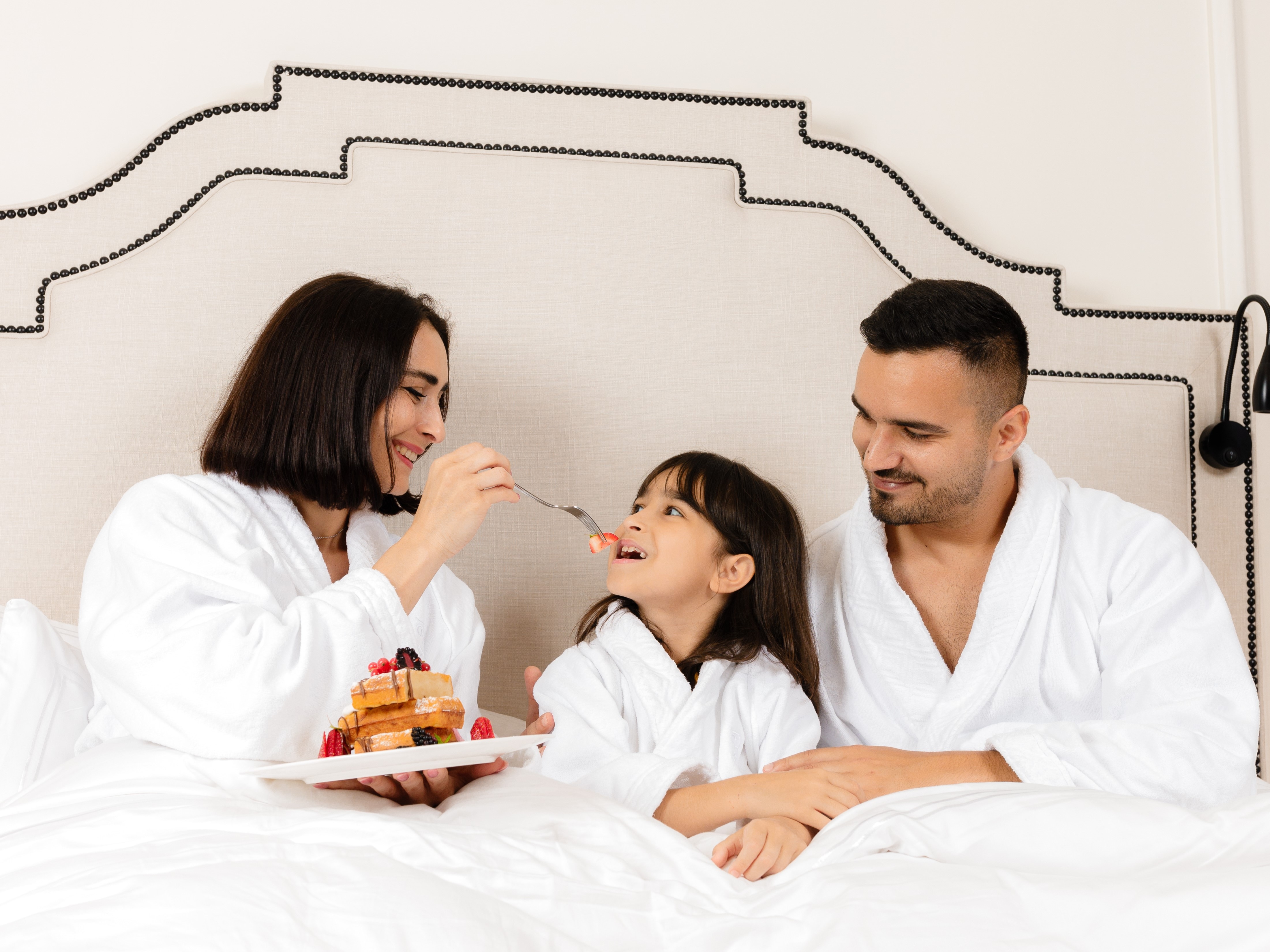 Family eatings snacks in bed