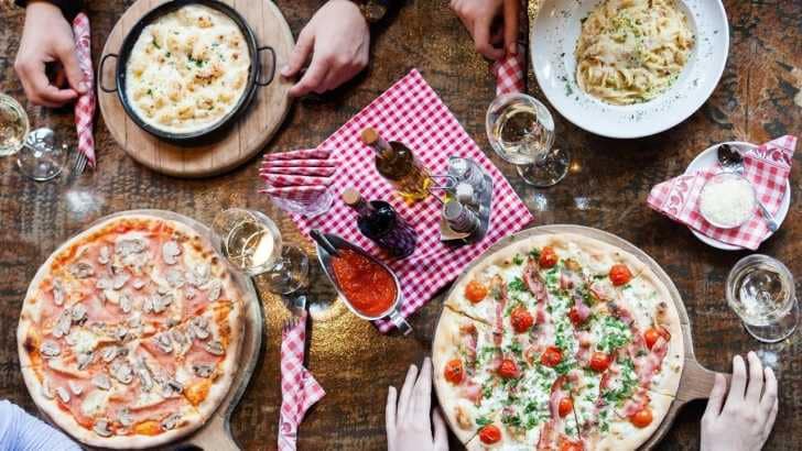 Pizzas and pasta dishes on a table