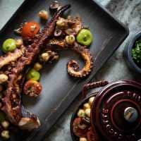 Grilled octopus tentacles and veggies on a plate
