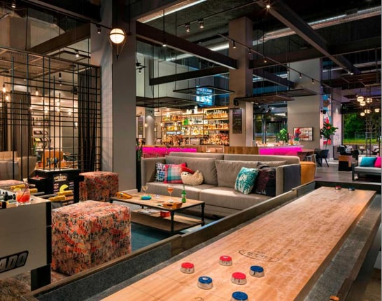 Funky lobby bar area with sofa & block seating, arcade, fooseball & shuffleboard games