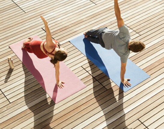 View from above of a man and woman doing side planks on yoga mats