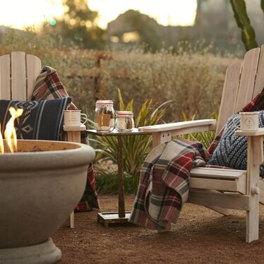 Two chairs by a cozy fire with blankets