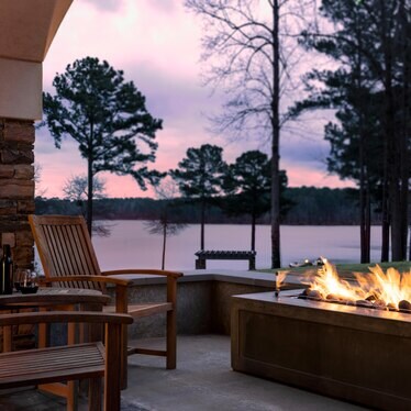Two chairs by a fire nearby the water view