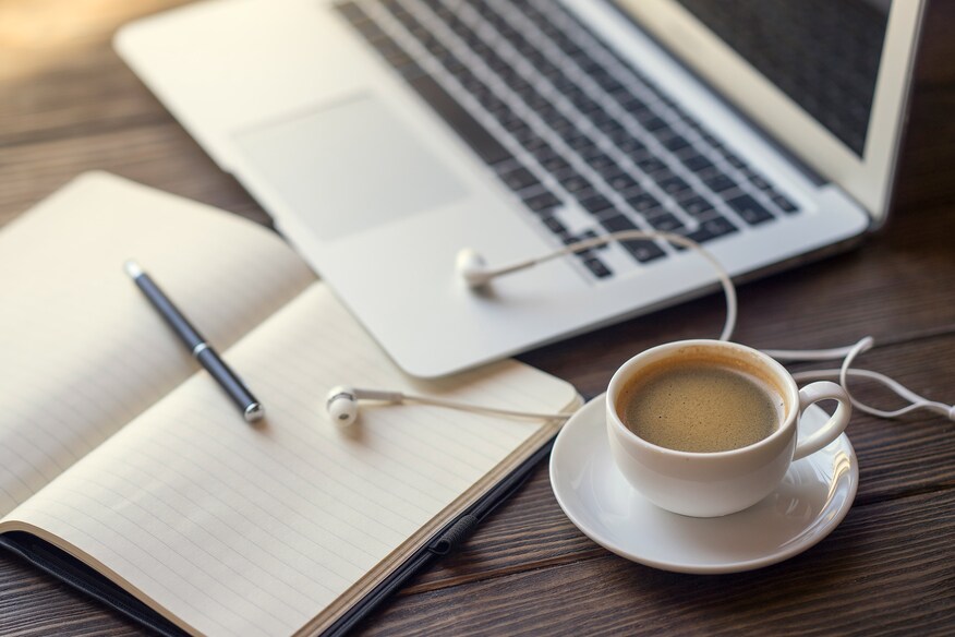 Laptop with notepad and coffee