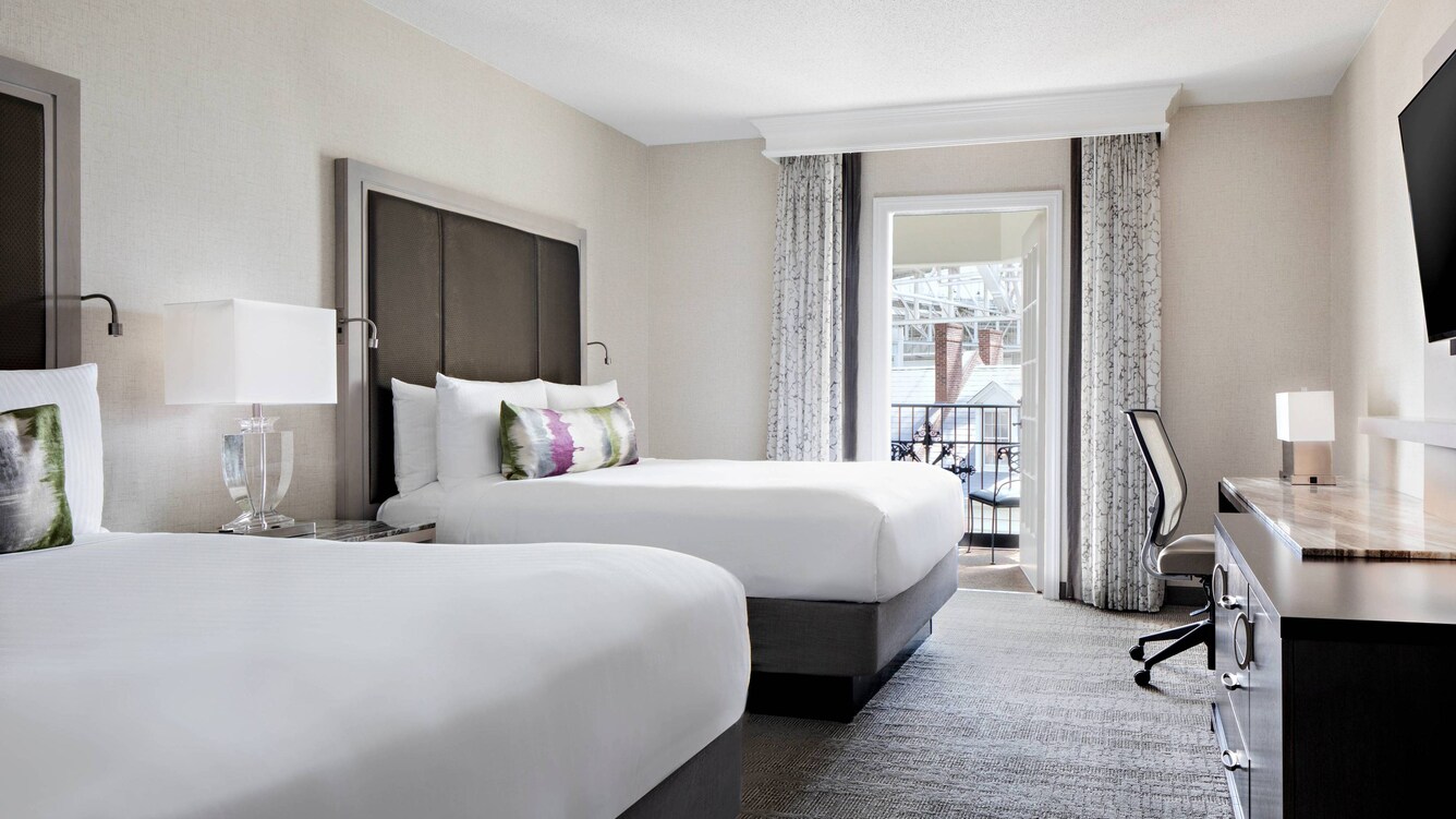 Guest room with two beds and nearby balcony