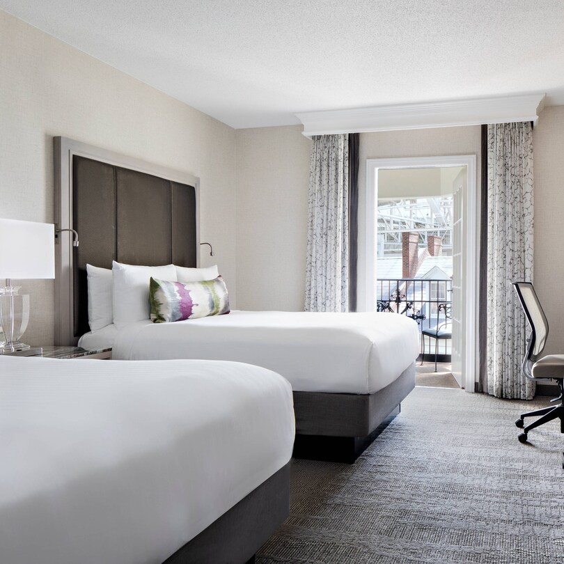Guest room with two beds and nearby balcony.