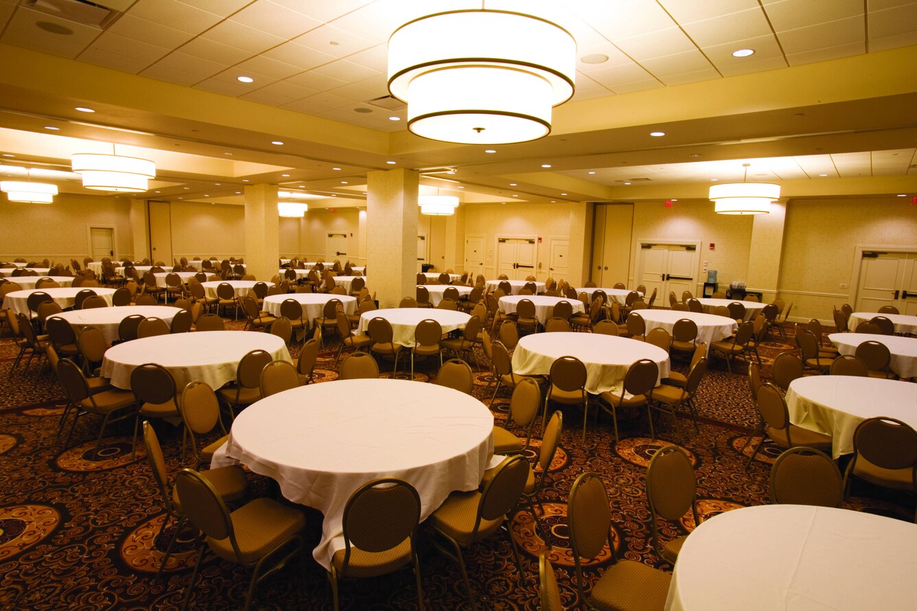 Large conference room with dozens of circular tables and chairs.