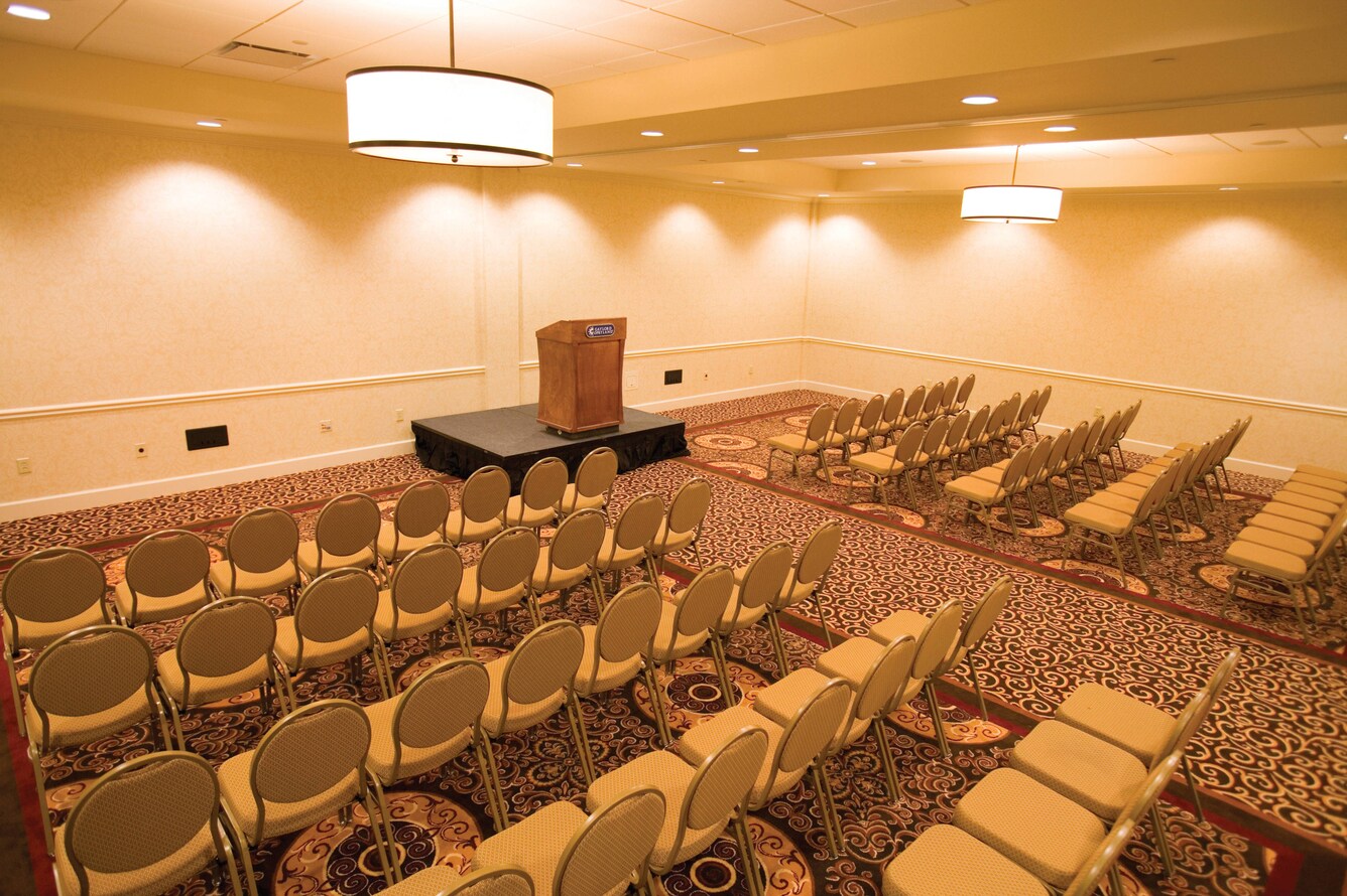 Rows of chairs in a meeting room facing a lectern.