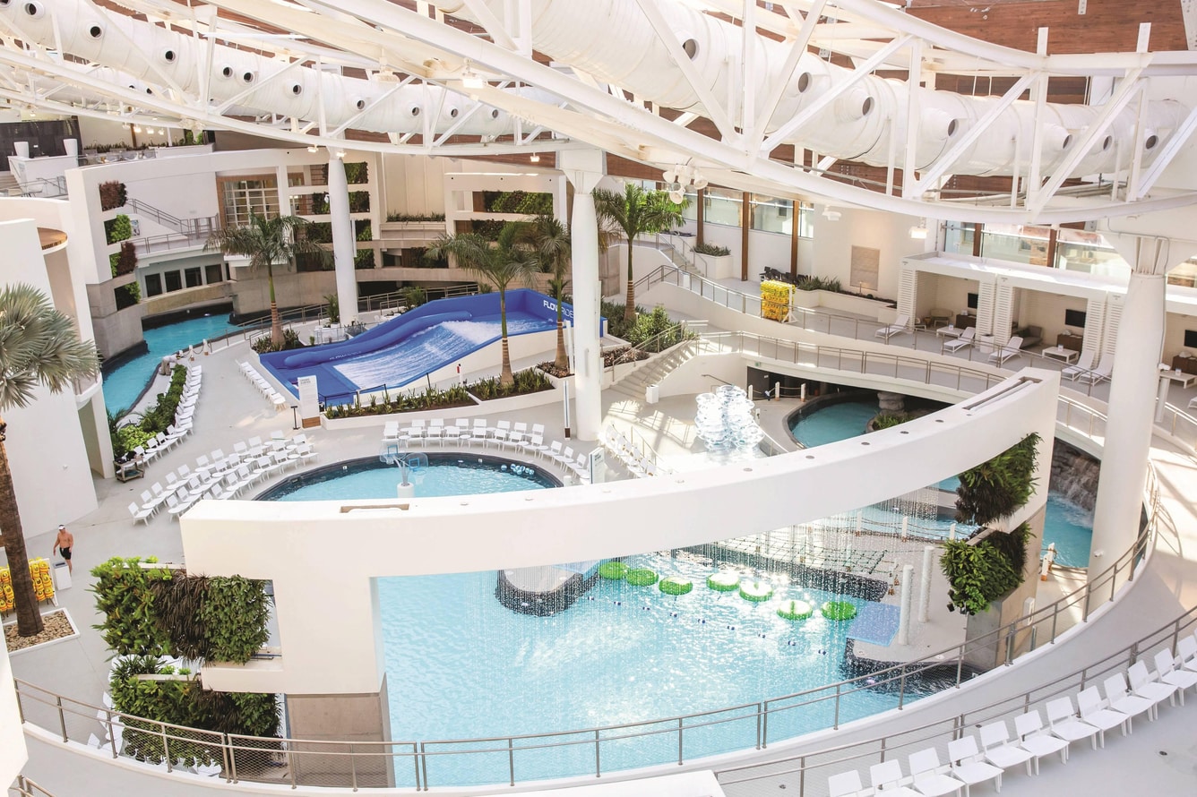 Indoor water park with waterfalls, lazy river, and wave machine.