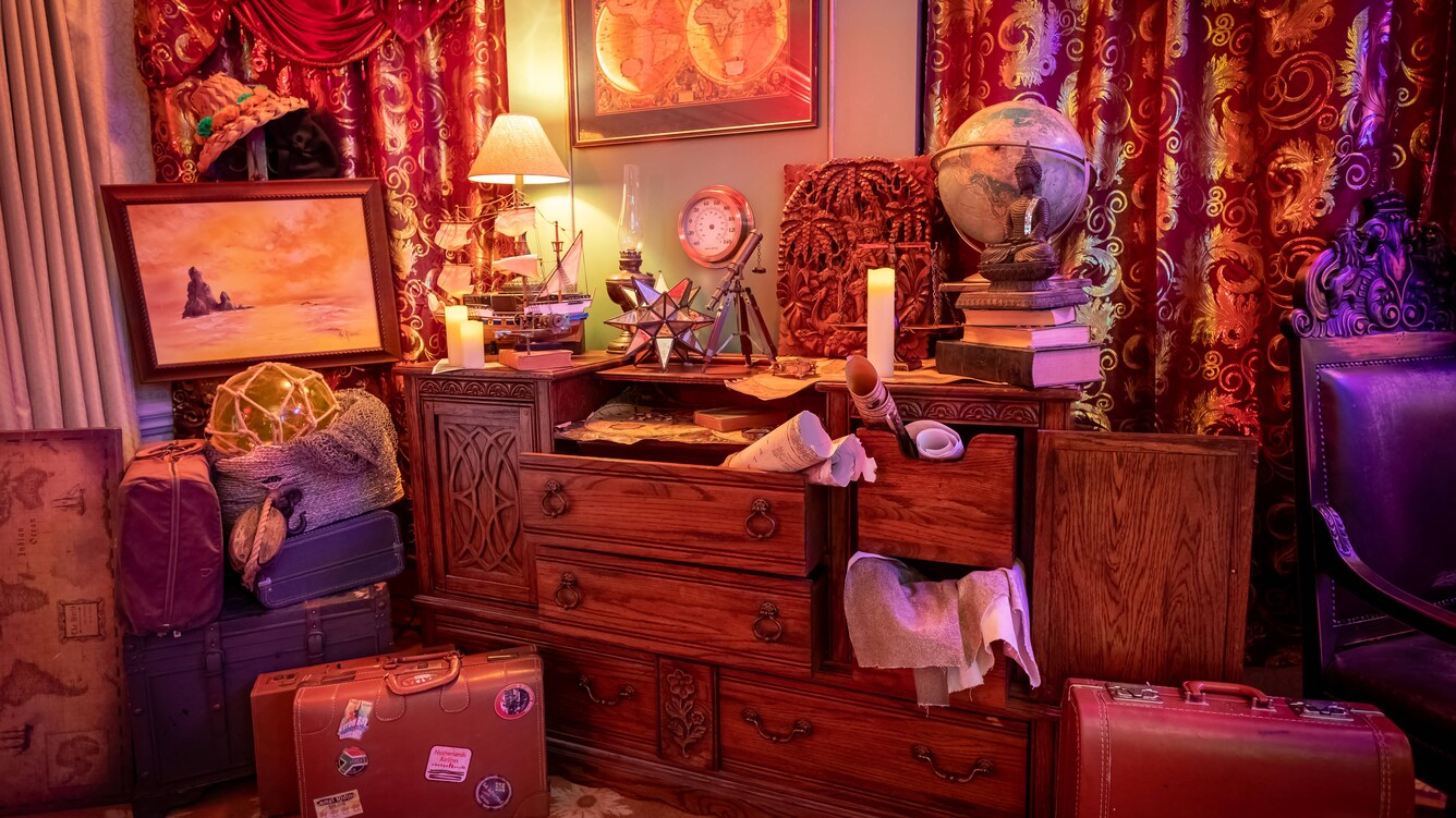 Chest of drawers full of artifacts with suitcases on the floor